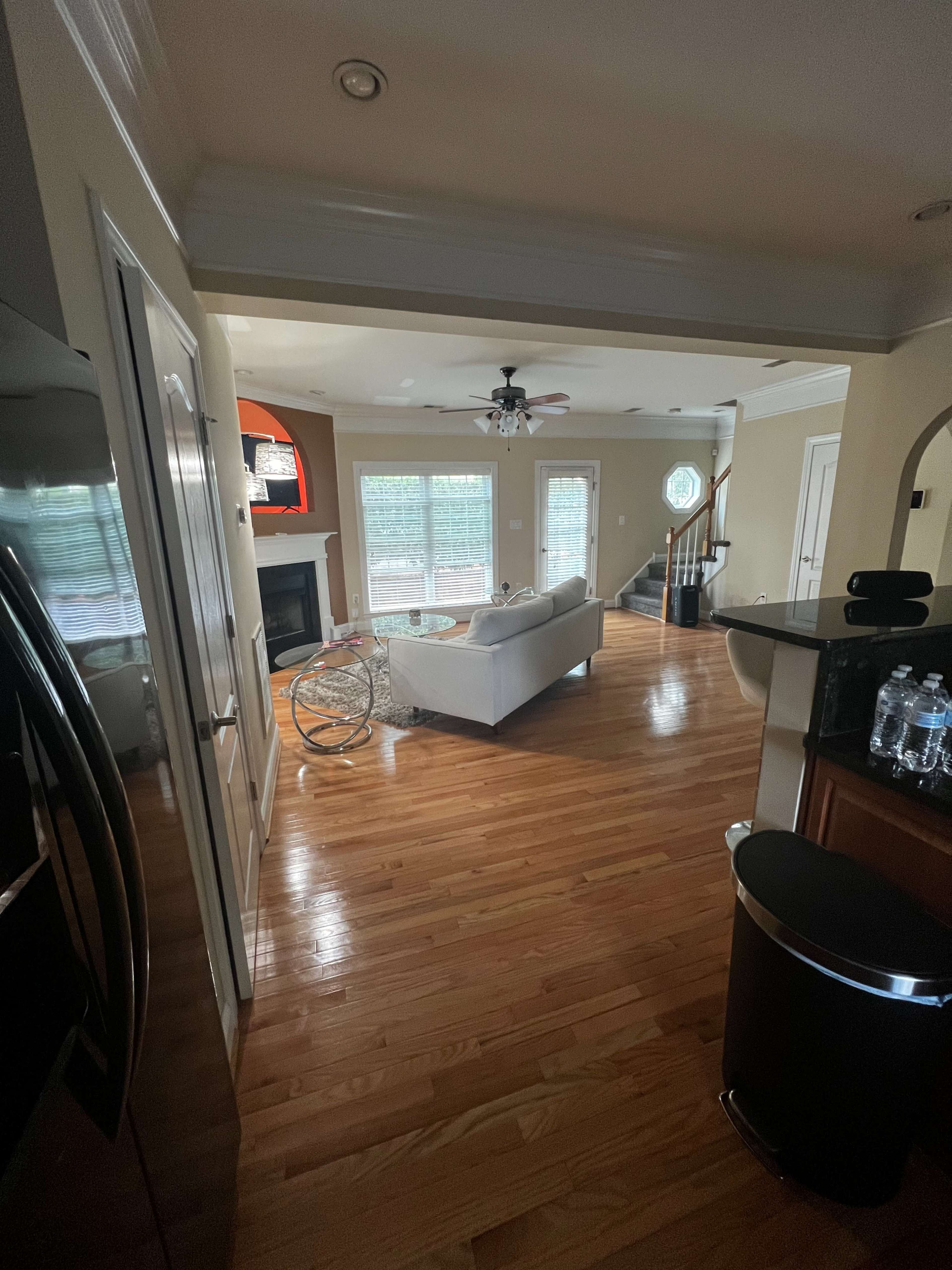 A living room with a sofa, coffee table, and wooden flooring, viewed from a doorway.