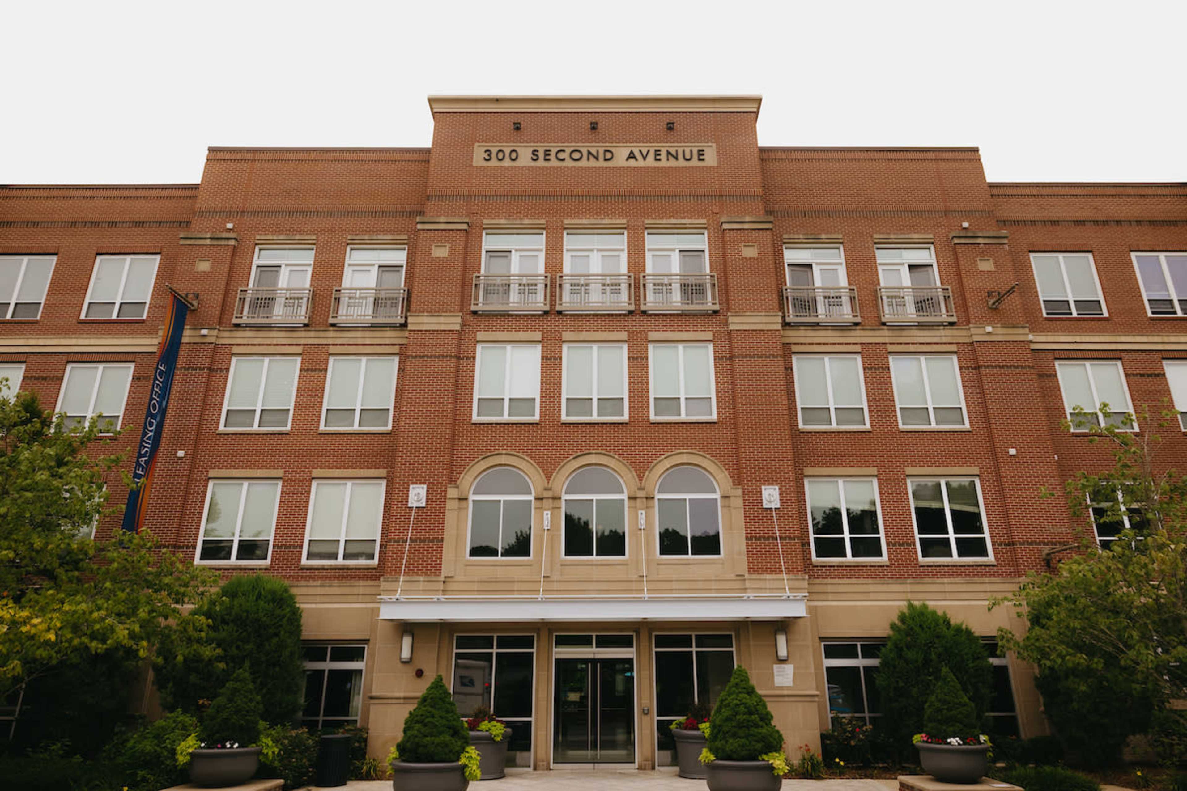 A multi-story brick building with large windows and an entrance at 300 Second Avenue.
