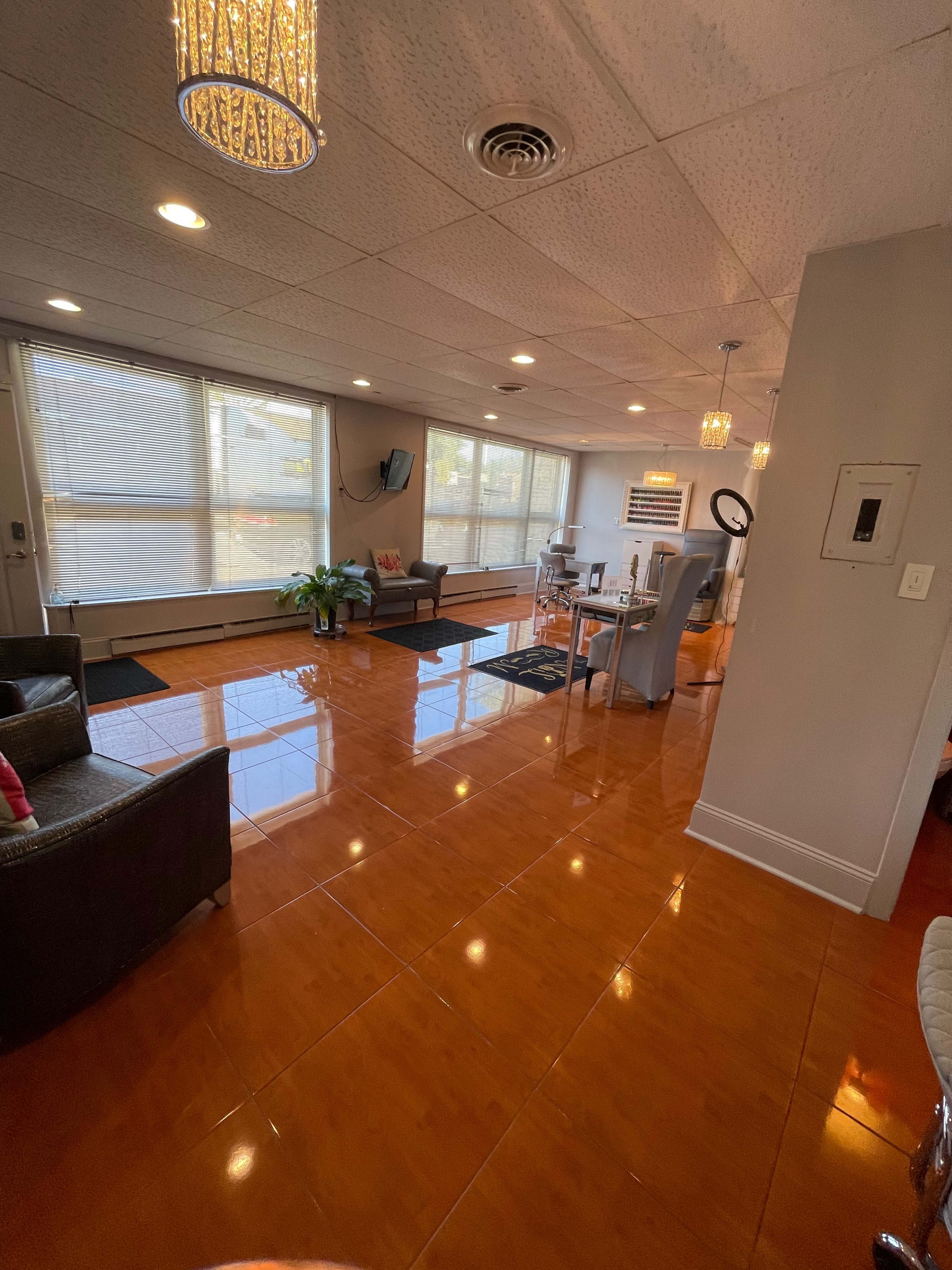A spacious, well-lit interior with shiny orange tiles, a seating area, and large windows allowing natural light.