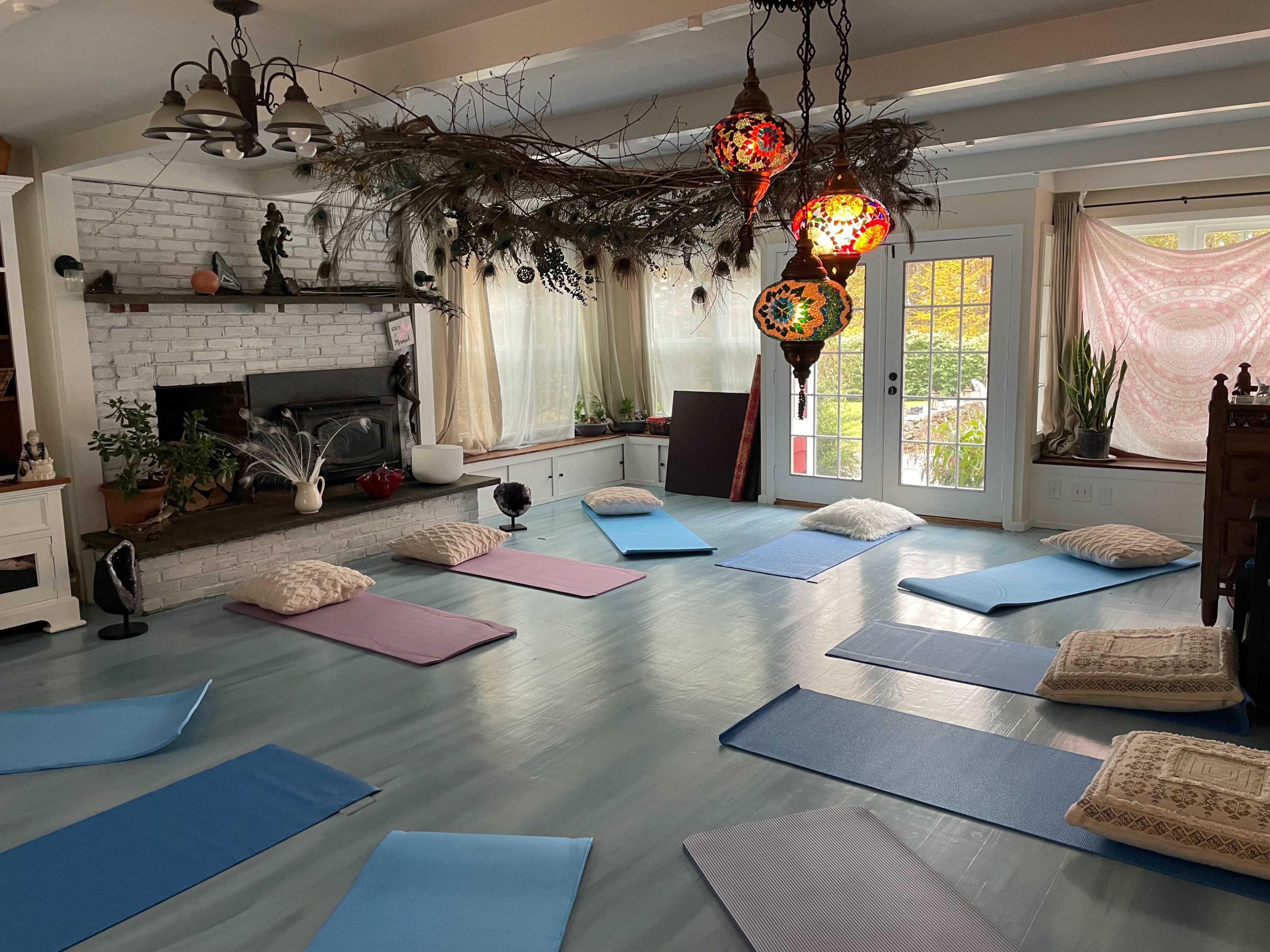 A spacious room with yoga mats arranged on the floor and decorative lanterns hanging from the ceiling.
