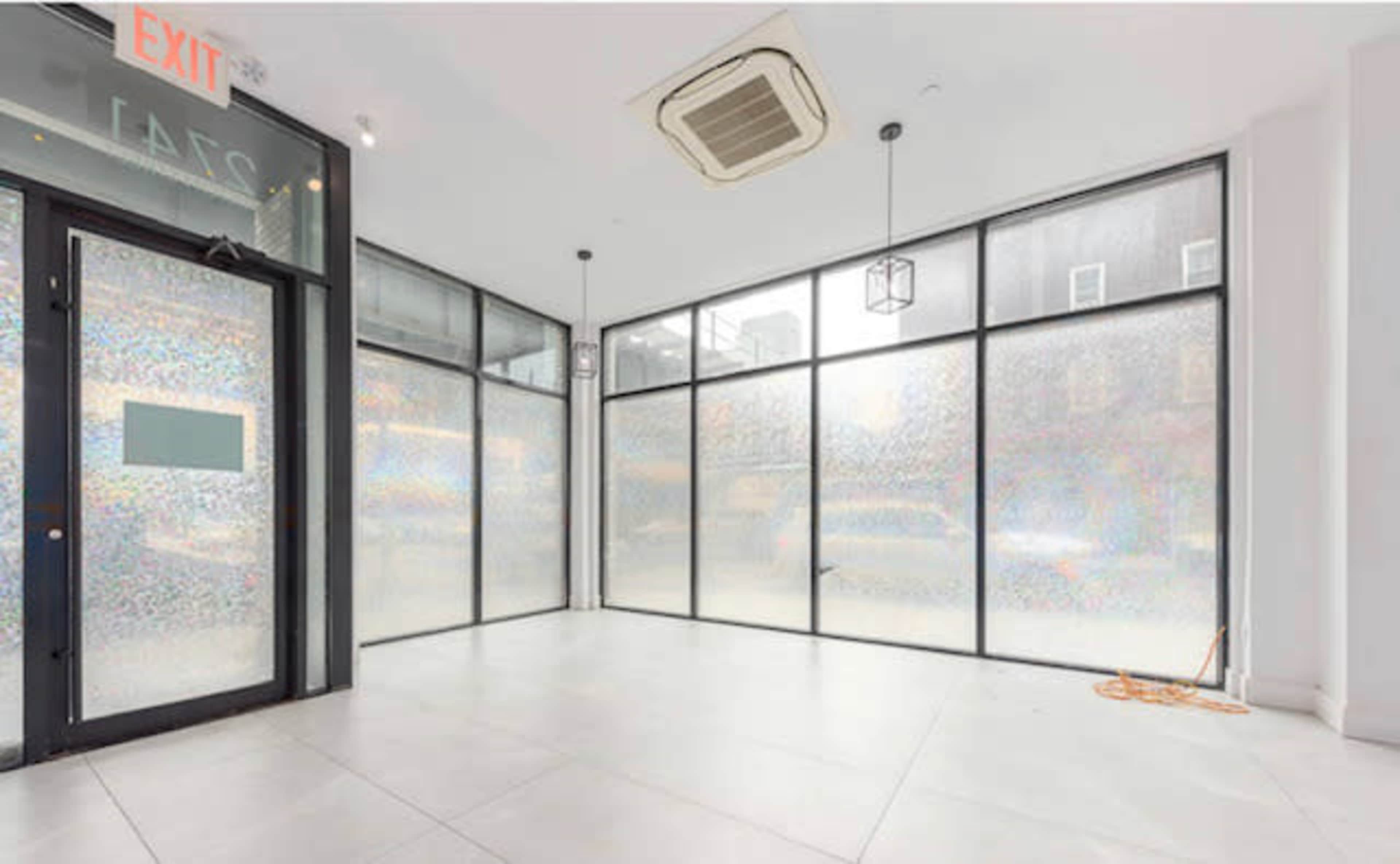 An empty retail space with large windows and a modern interior design.