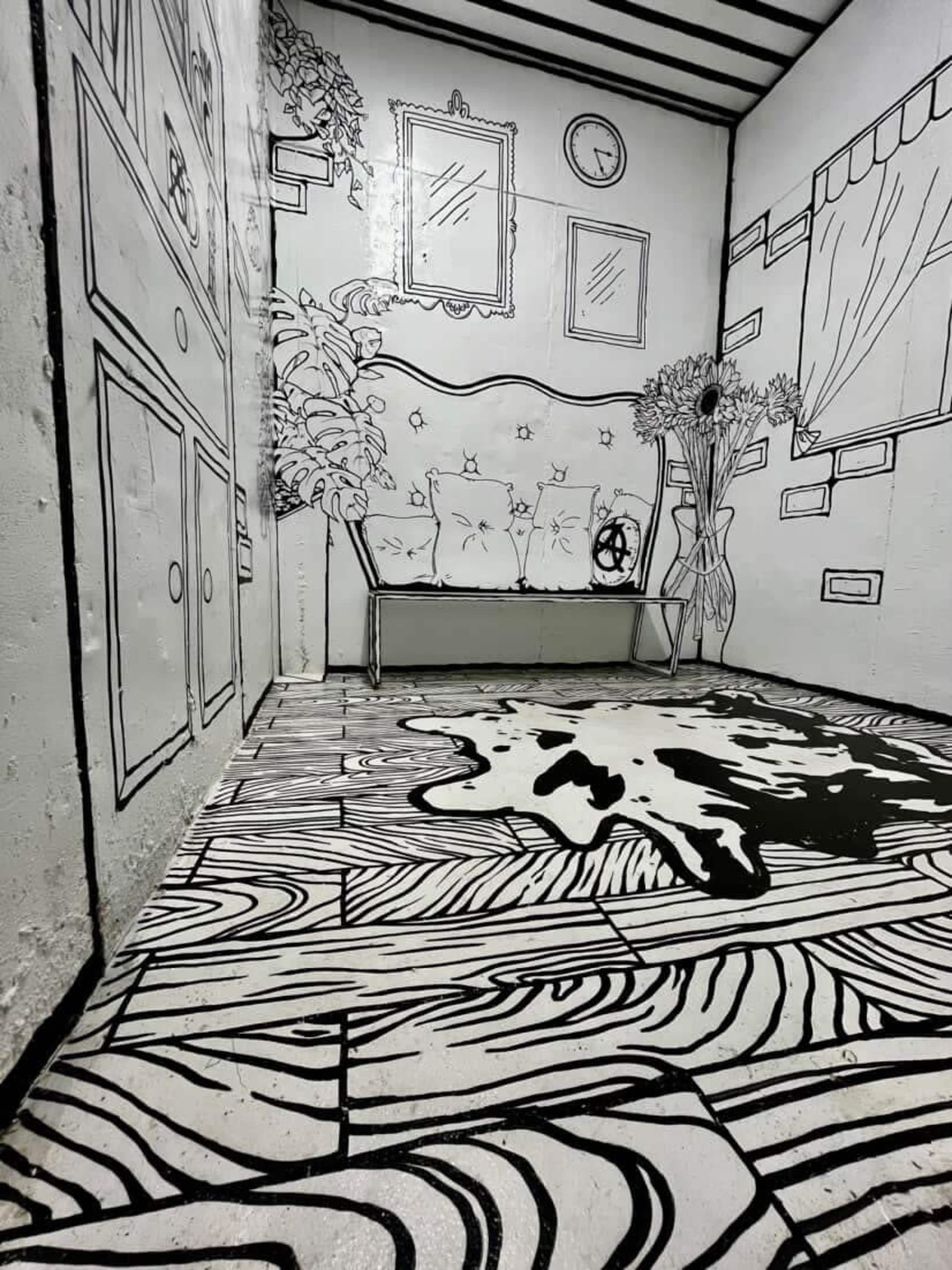 The image shows a room with black and white line art depicting furniture, a clock, and a vase with flowers on a floor that resembles wooden planks.