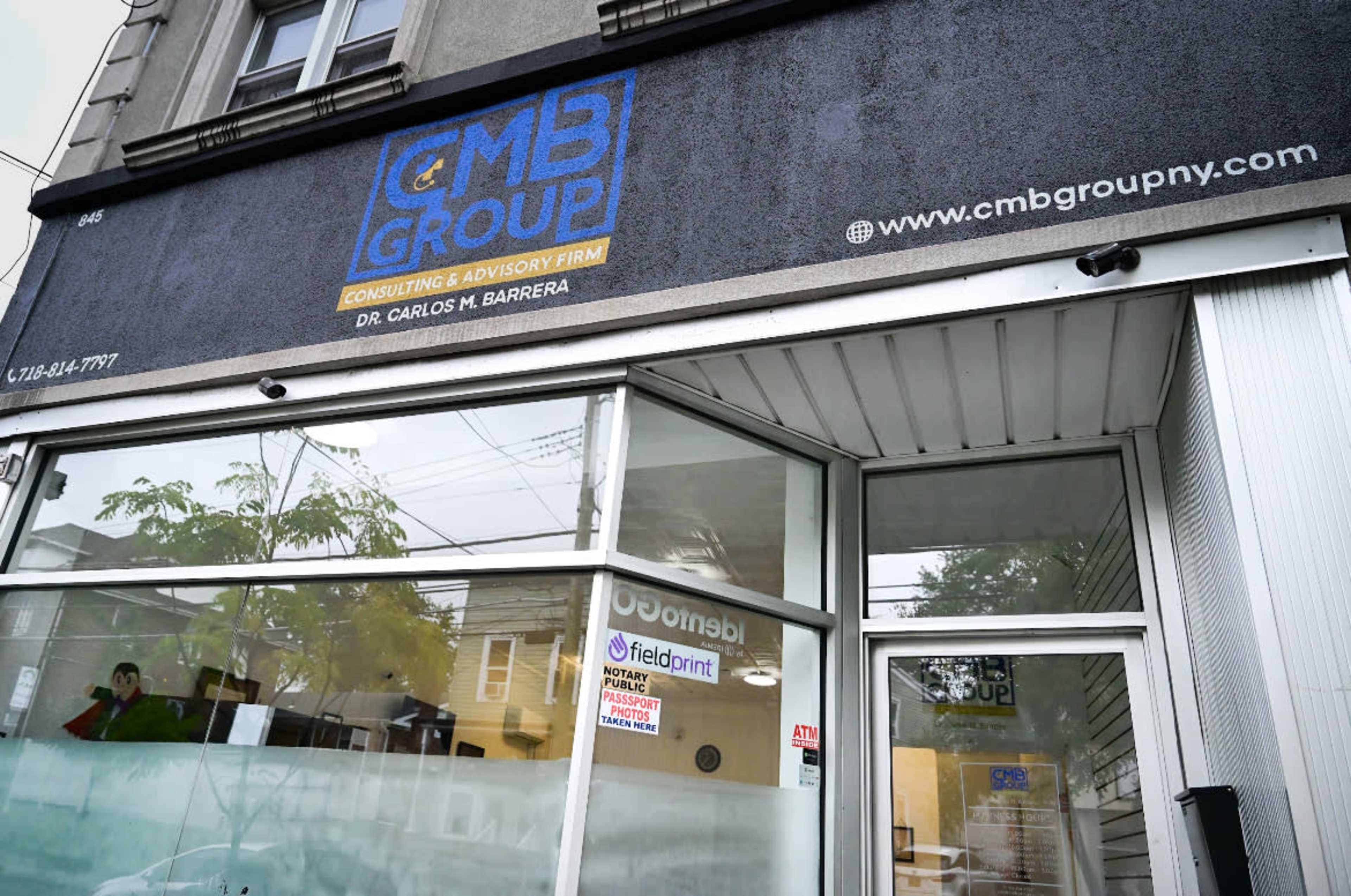 The image shows the exterior of a consulting and advisory firm named CMB Group, featuring a blue sign with the firm's name and contact information above a glass window.