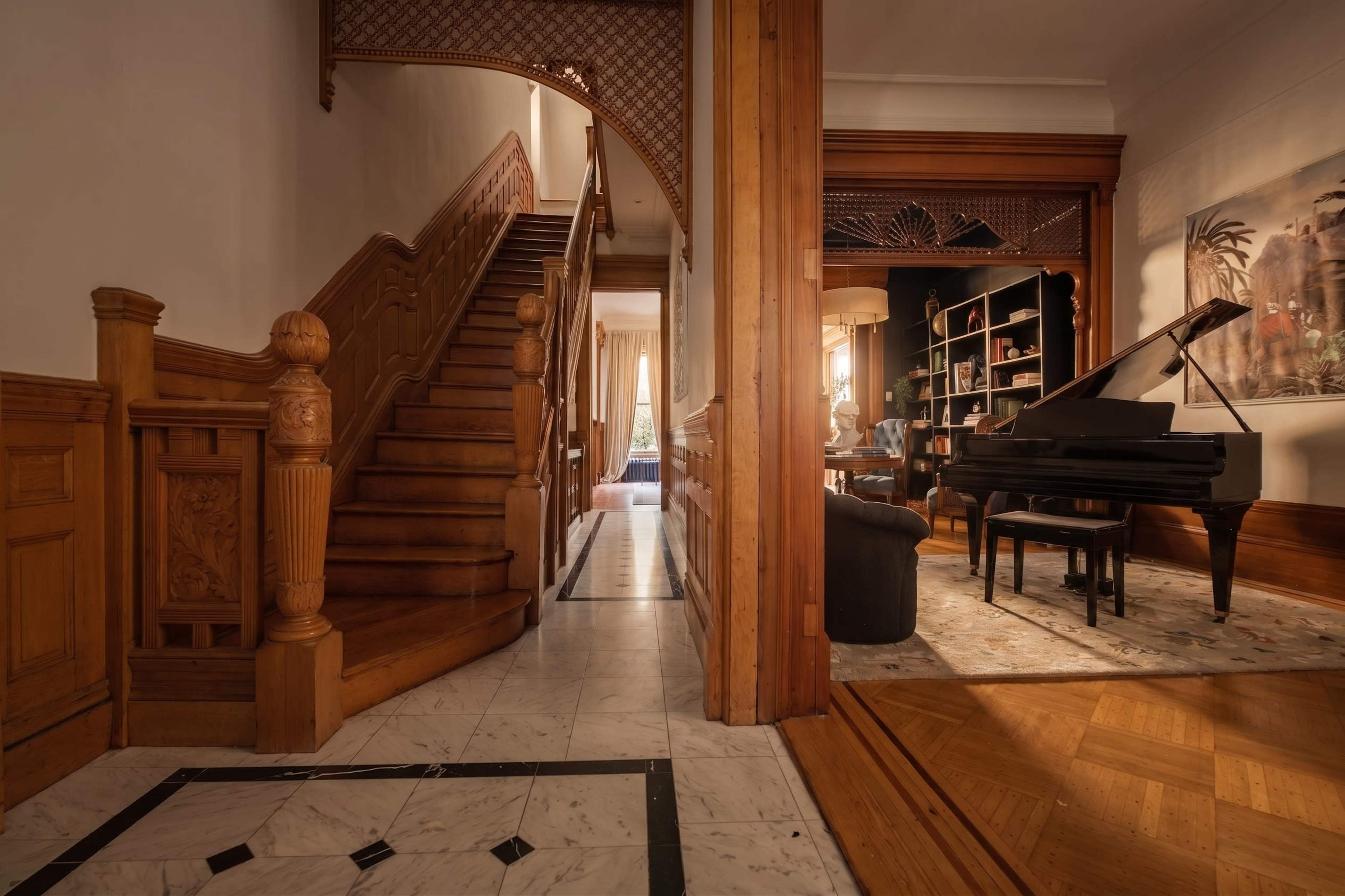 The image features an elegantly designed interior with a wooden staircase and a grand piano positioned next to a bookshelf in a well-lit room.