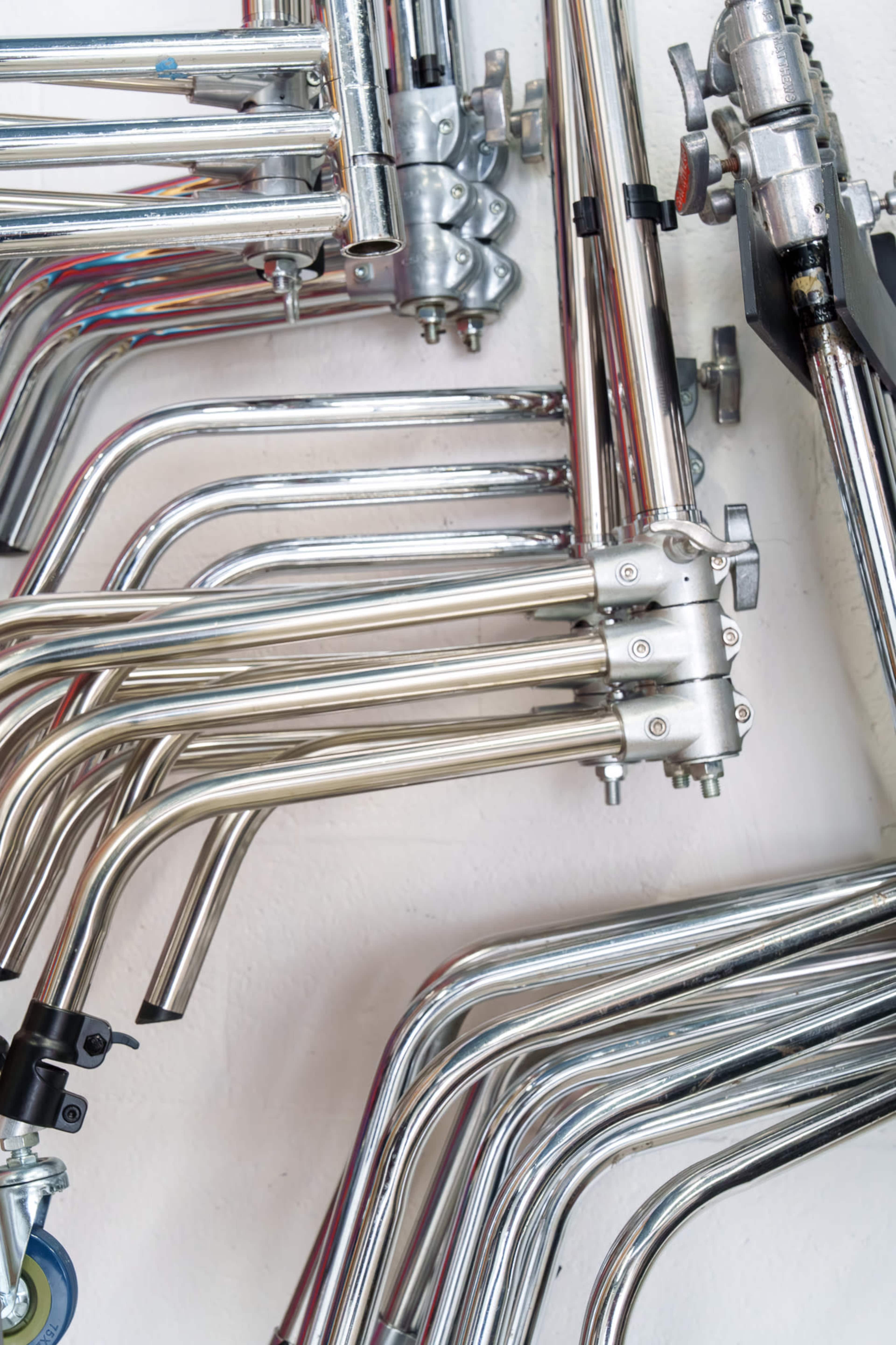 The image shows an arrangement of metal tubing and connectors mounted on a wall.