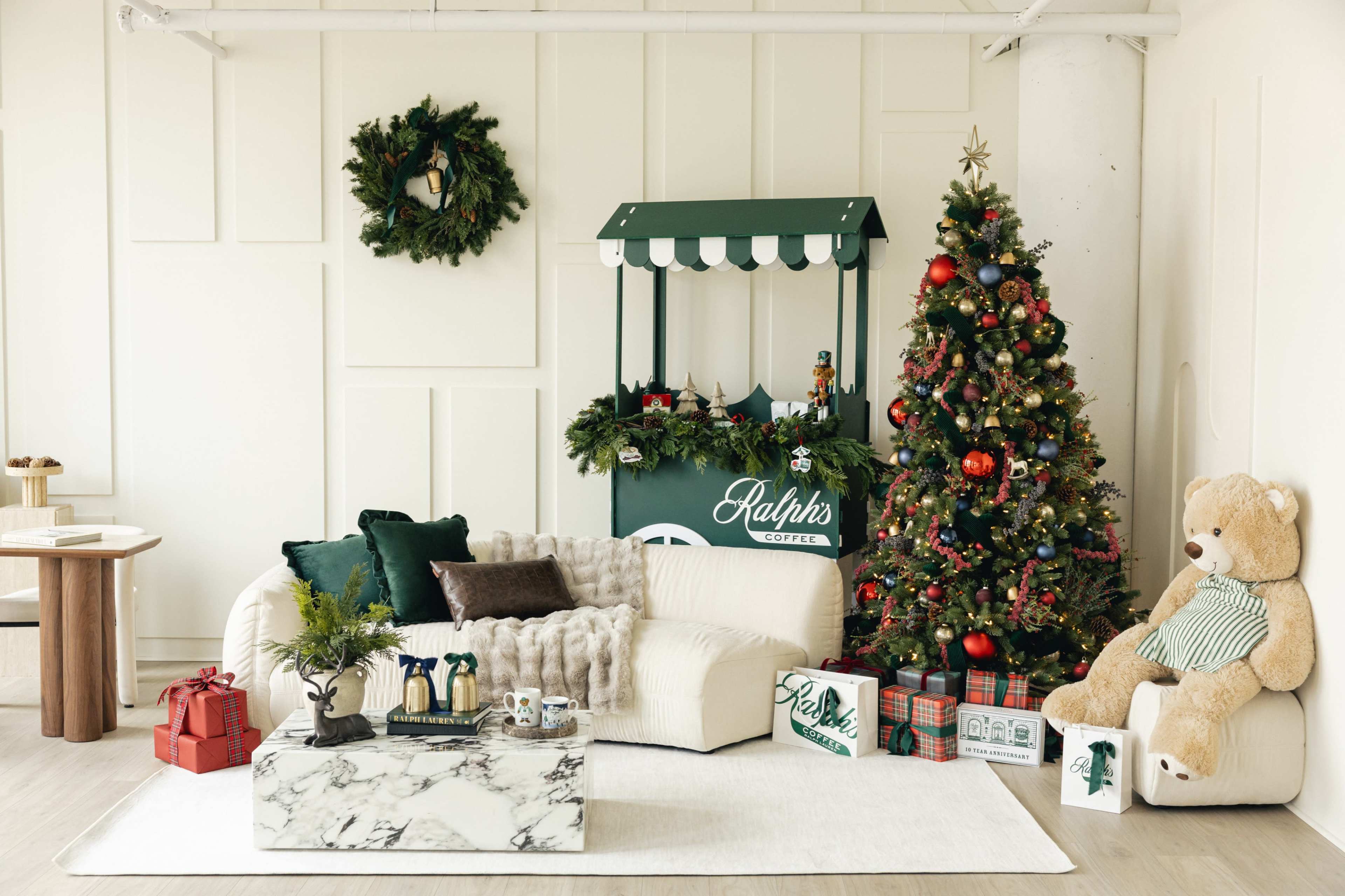 The image features a cozy living room adorned with a decorated Christmas tree, a festive coffee stand, and various holiday-themed decorations.