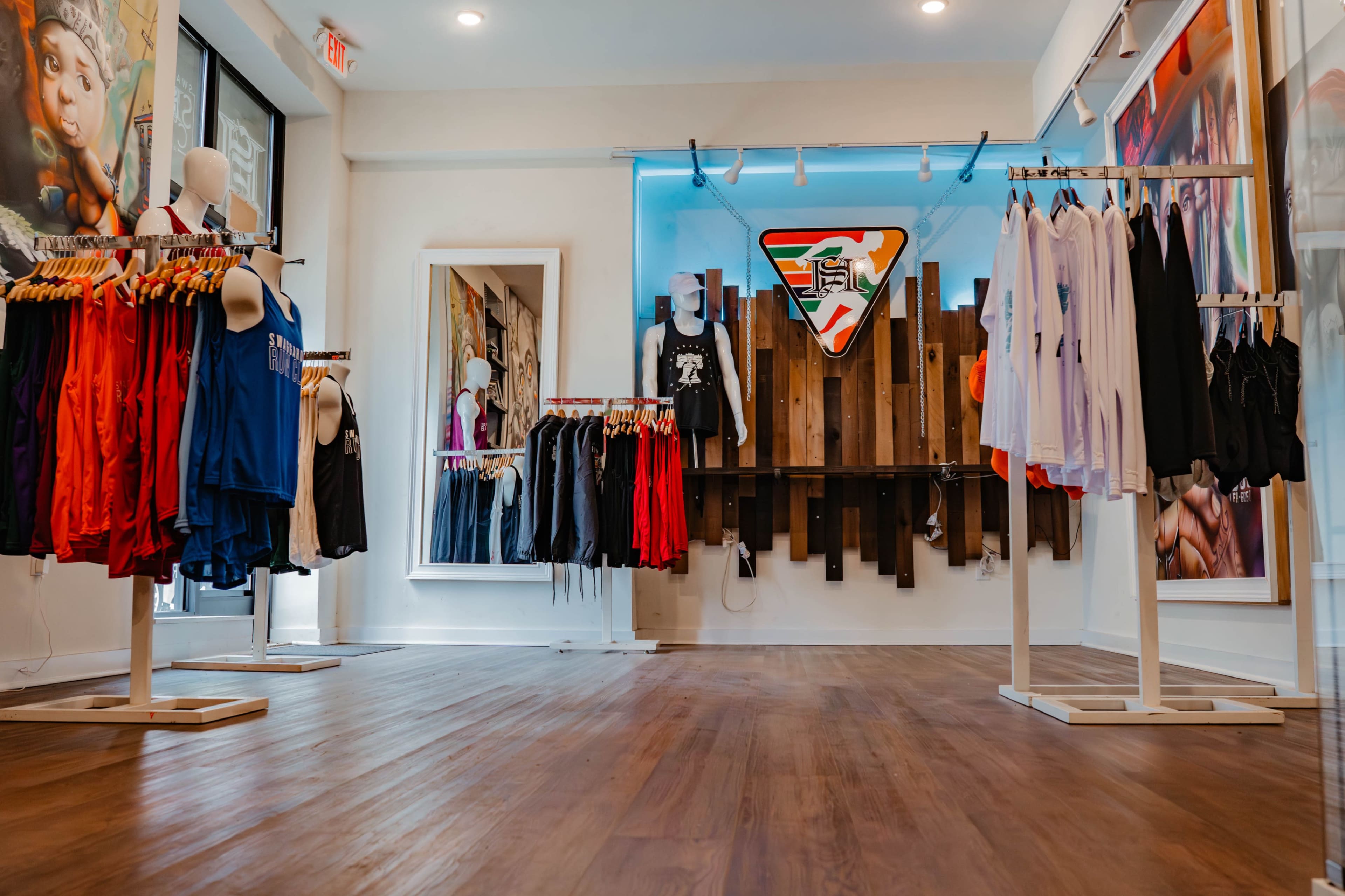 A modern retail space featuring clothing racks filled with various athletic apparel against a brightly lit backdrop.