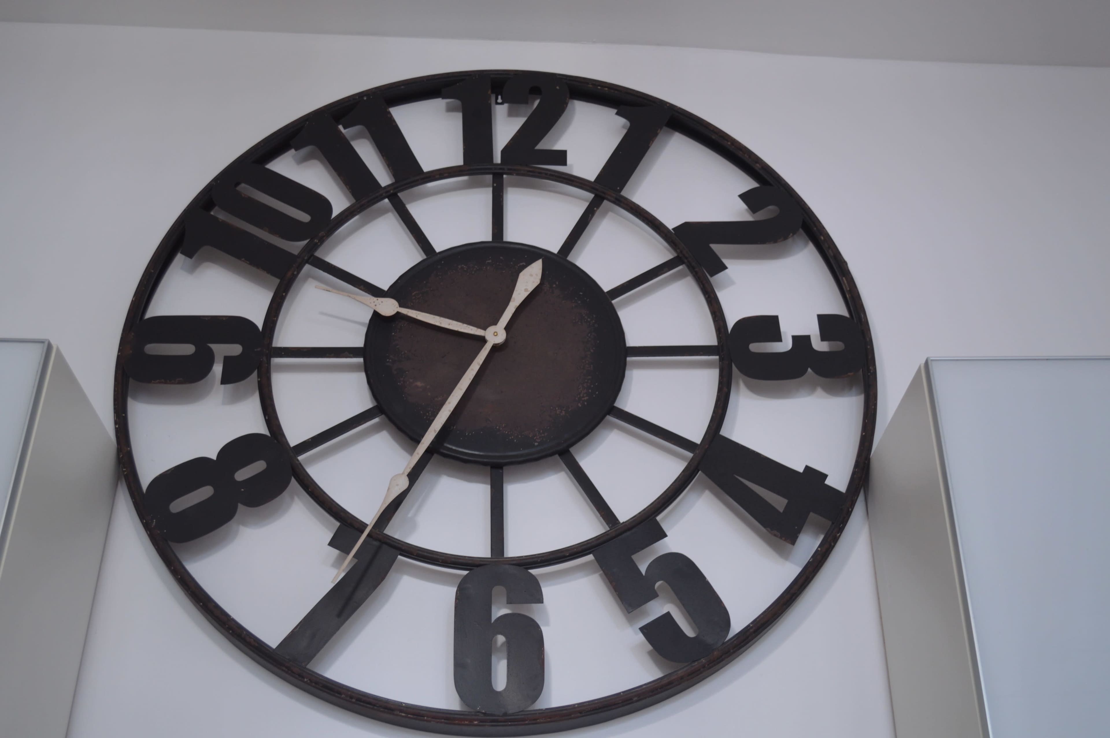 A large, round wall clock with bold black numbers and minimalistic hour and minute hands.