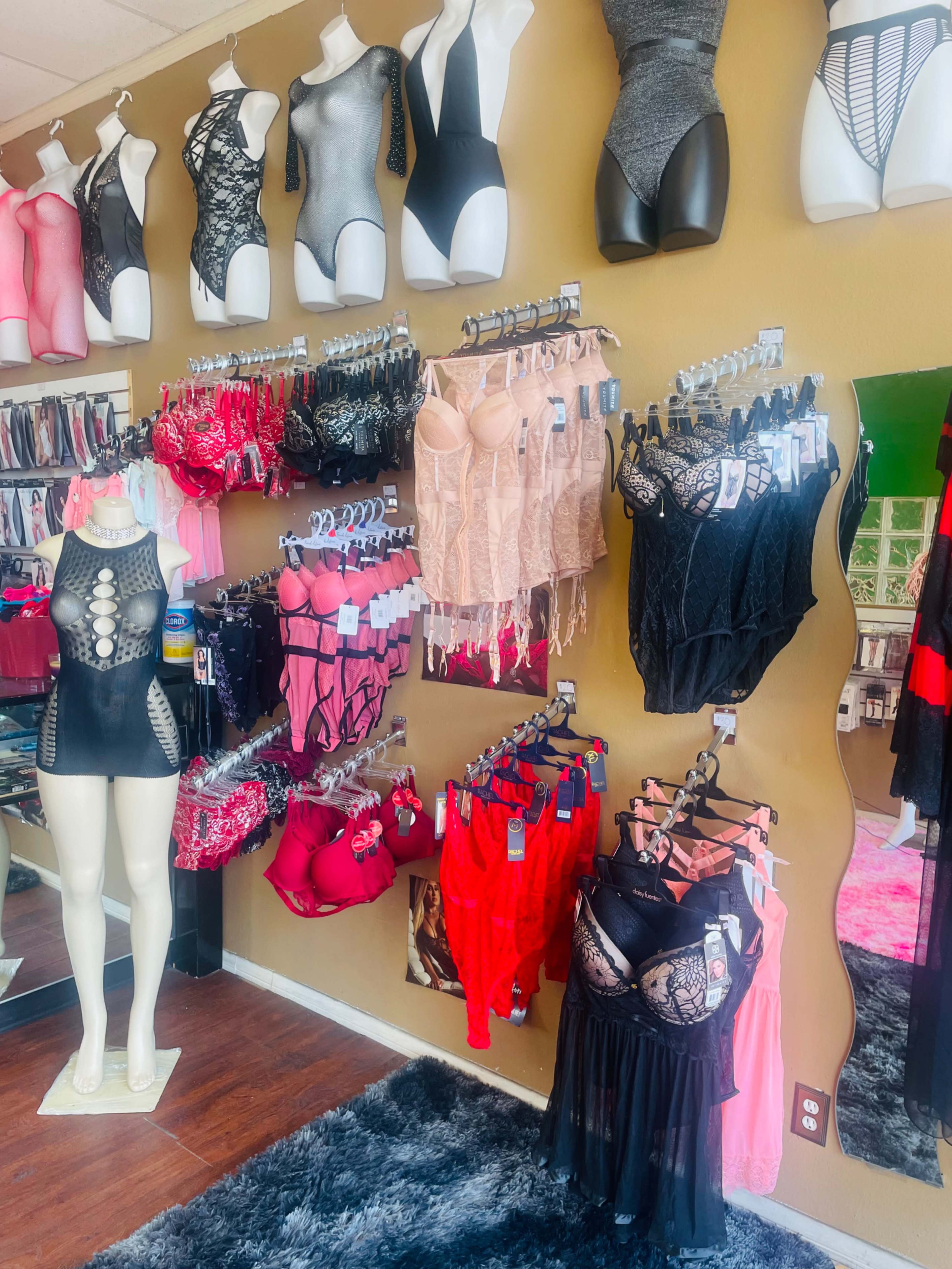 A retail display featuring an array of lingerie and bodysuits arranged on walls and mannequins.