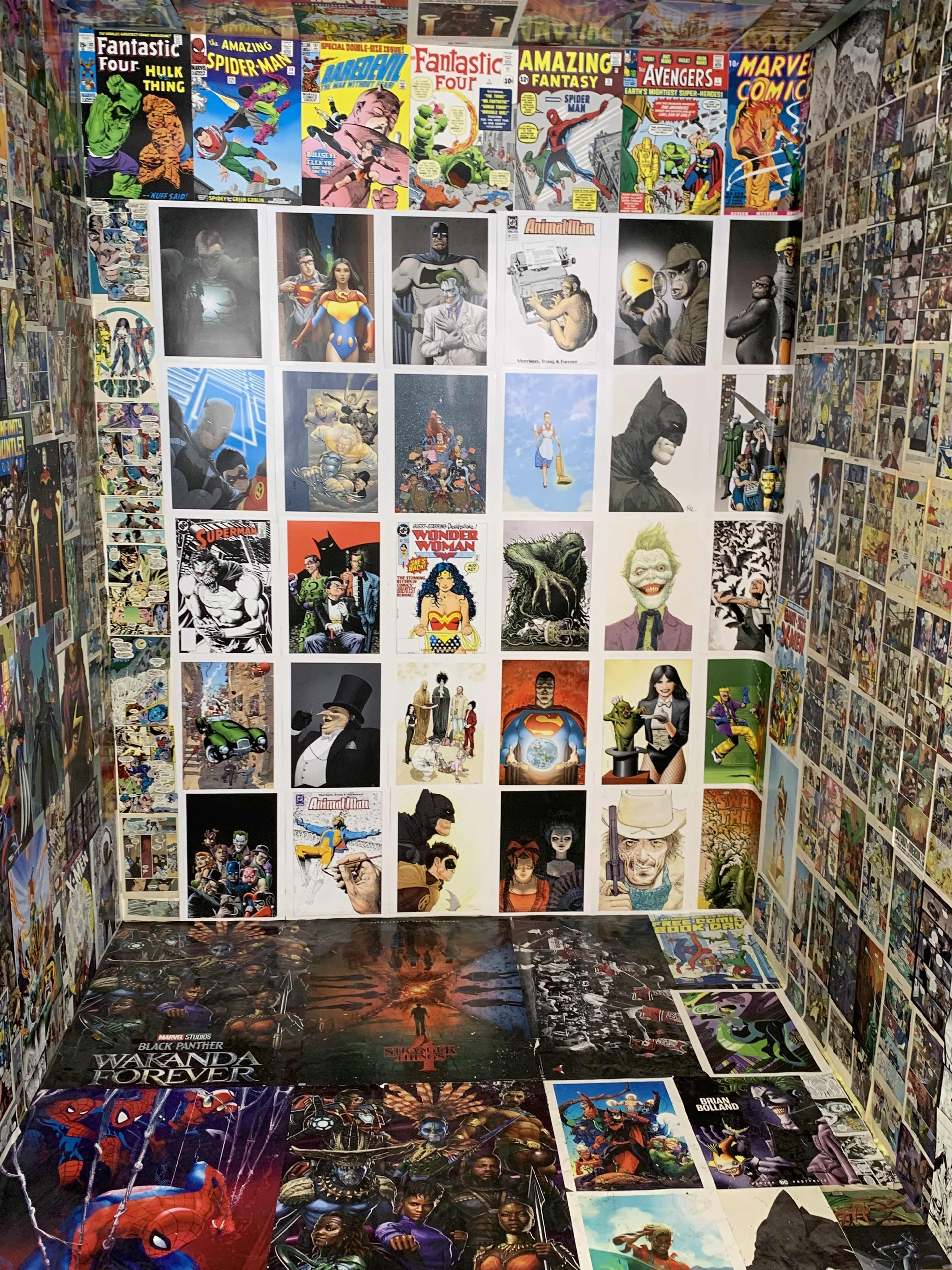 A room with walls covered in various comic book and movie posters, featuring superhero and sci-fi characters, along with a floor adorned with posters.