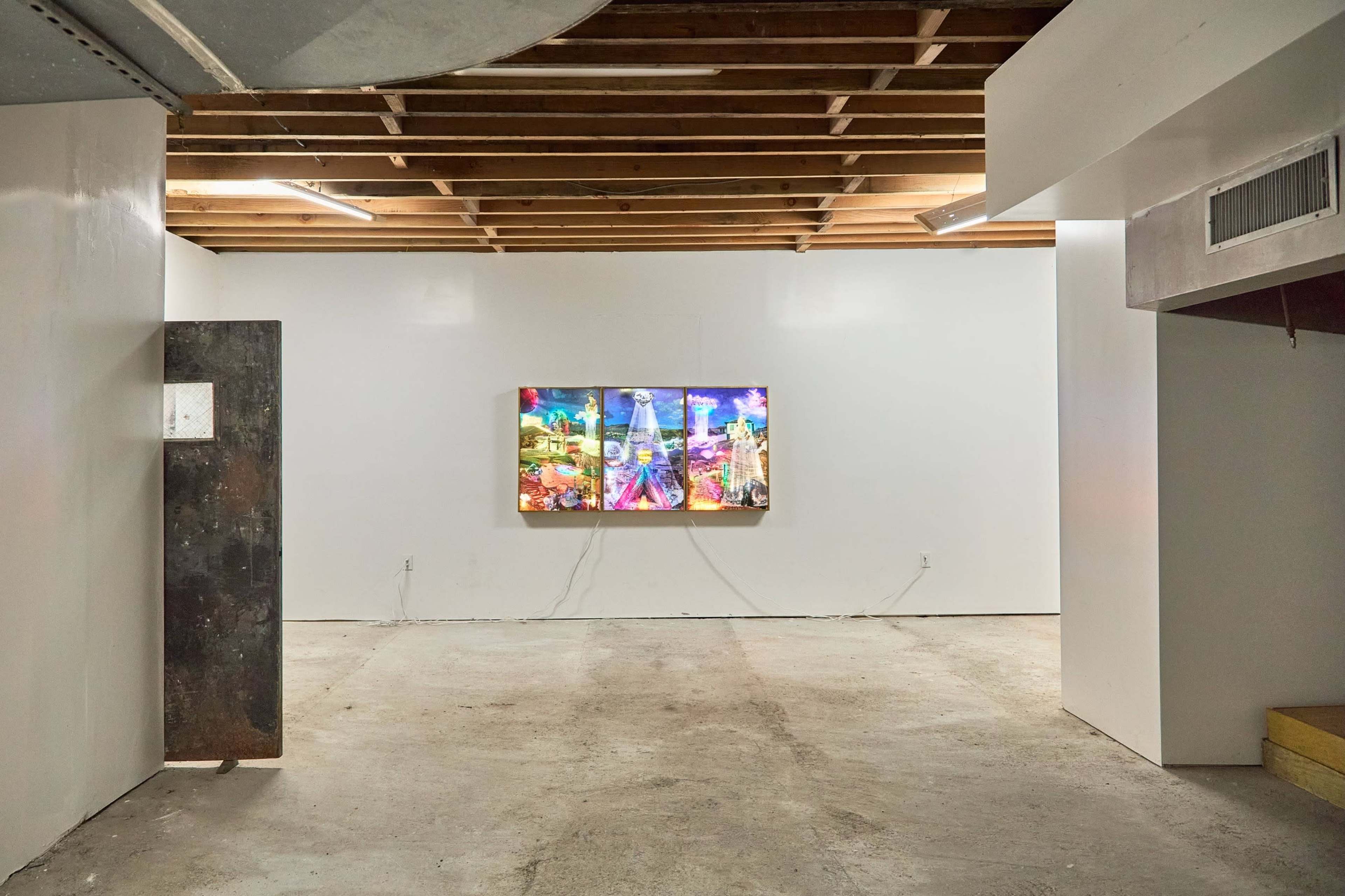 The image shows a minimalist art gallery featuring a colorful artwork hanging on a white wall, concrete flooring, and exposed wooden ceiling beams.