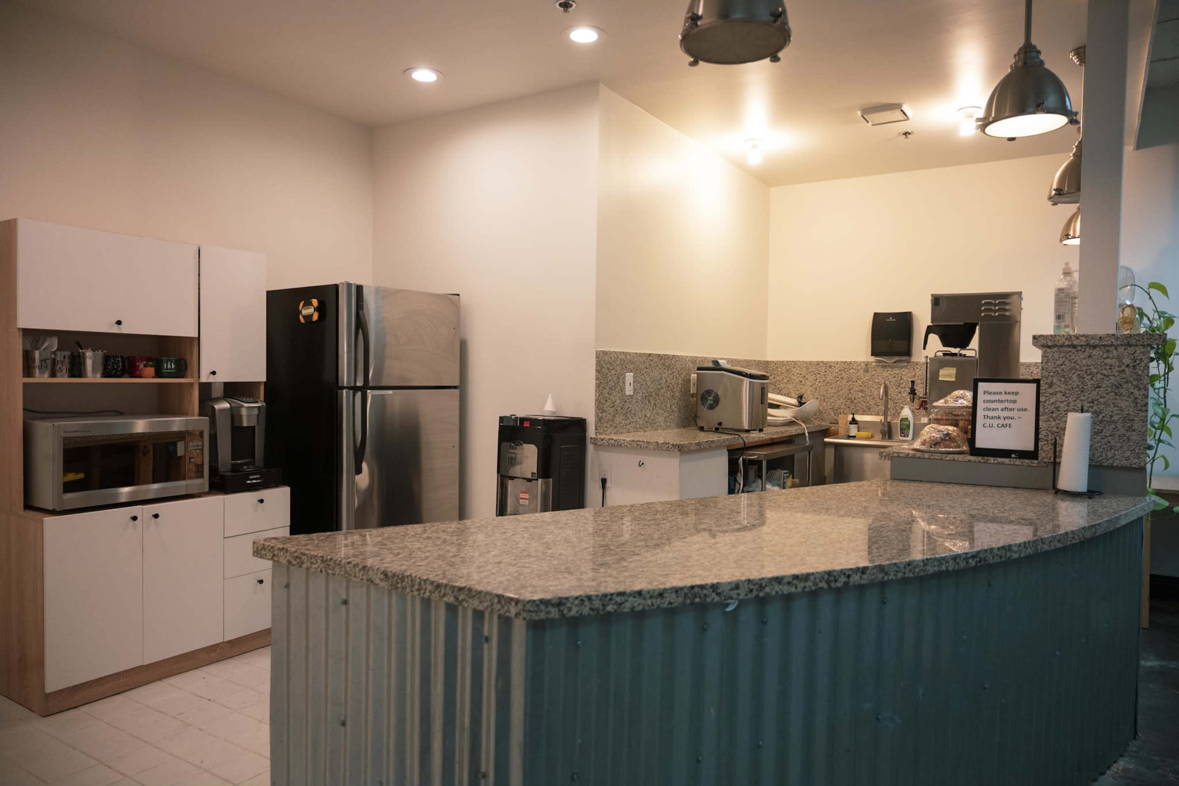 A kitchen space featuring stainless steel appliances, a granite countertop, and wooden cabinetry.