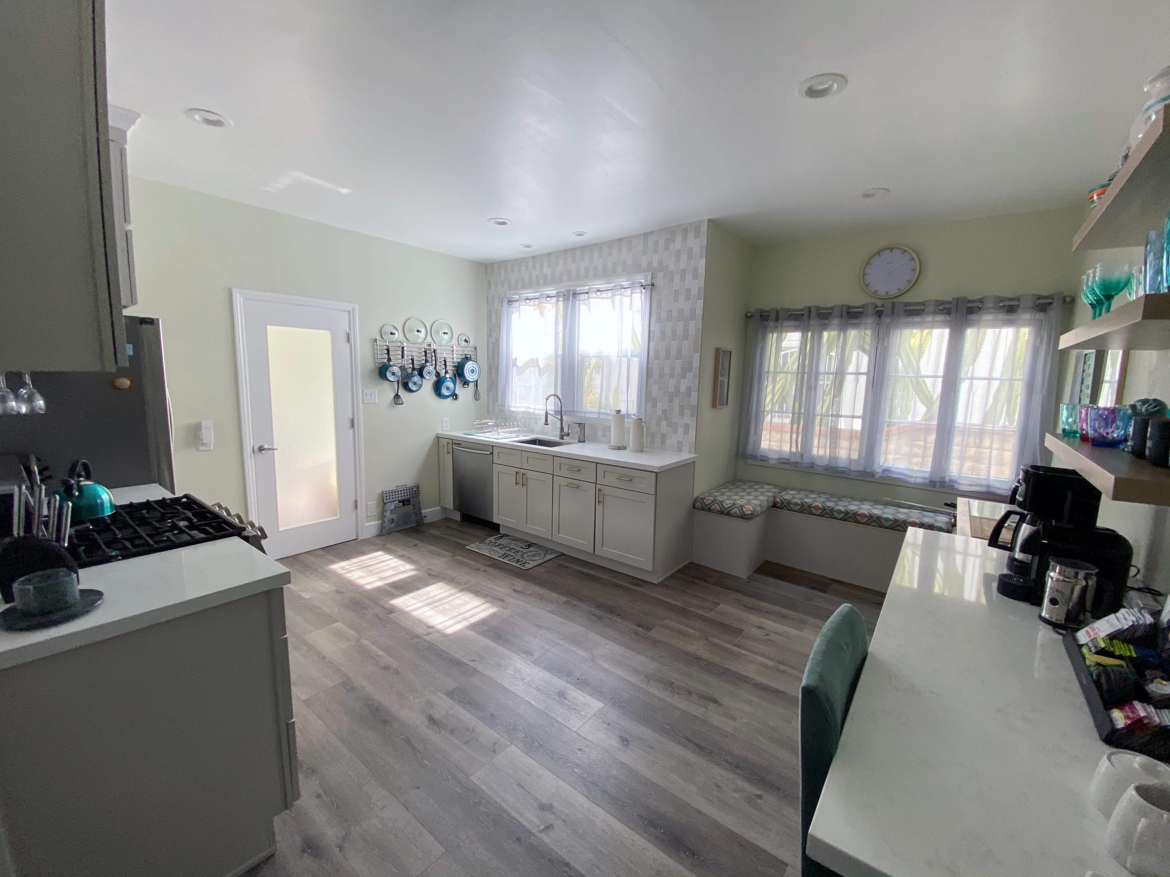 A bright kitchen features a window seat, modern cabinetry, and a coffee station with a coffee maker.