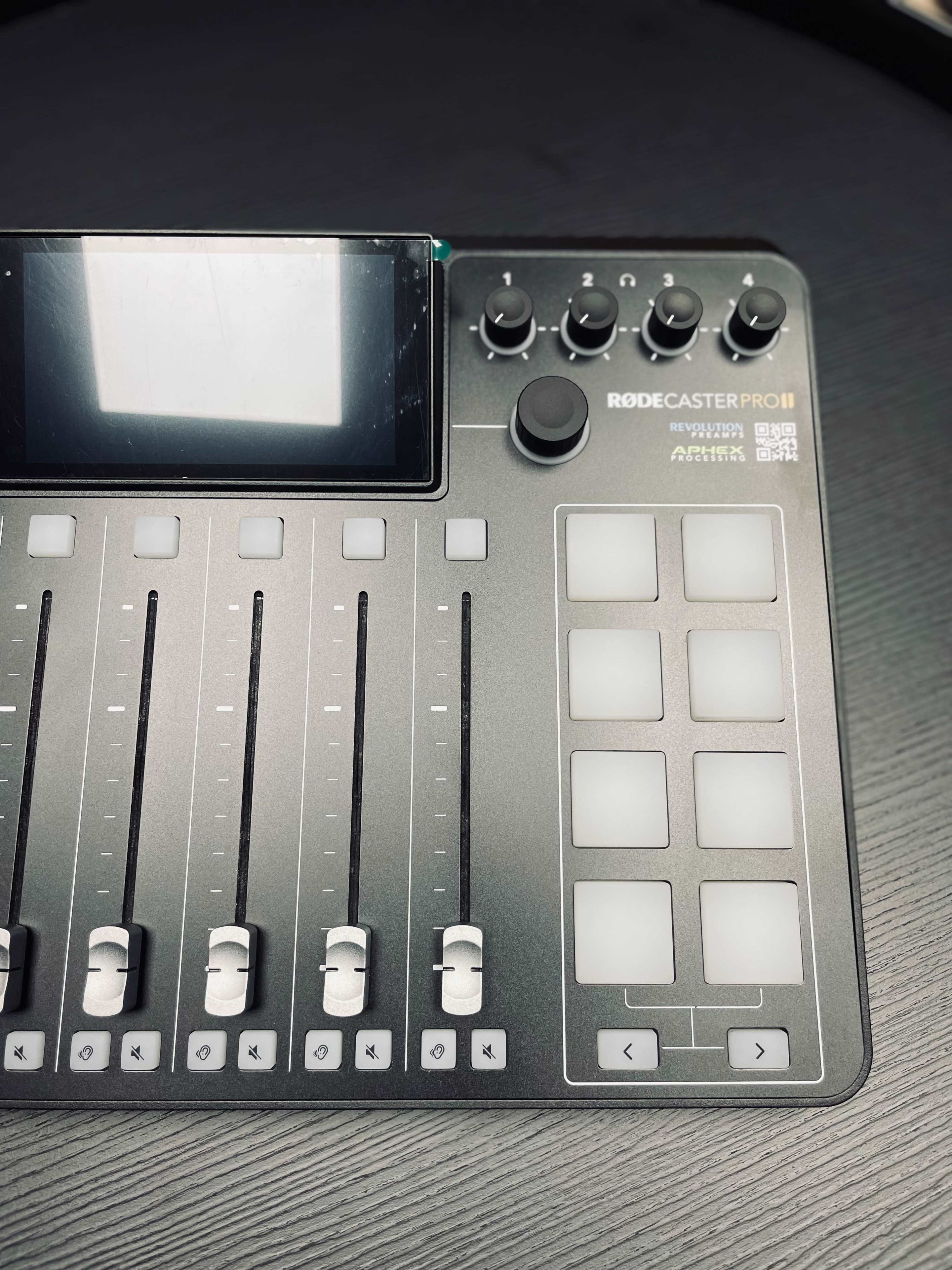 A Rodecaster Pro II audio mixing console with several sliders, knobs, and a touchscreen interface.