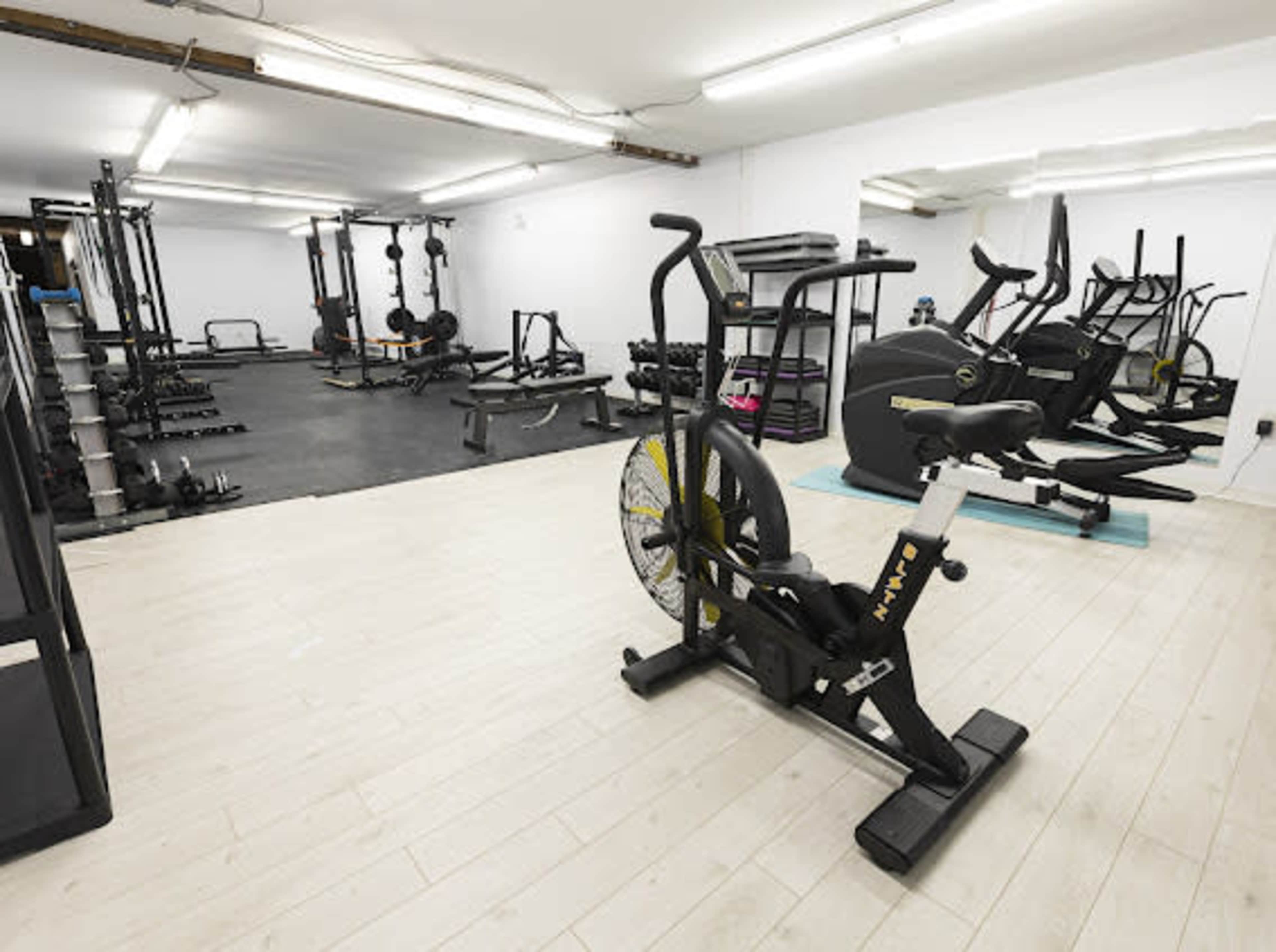 A gym interior equipped with exercise machines, weights, and a bike in the foreground.