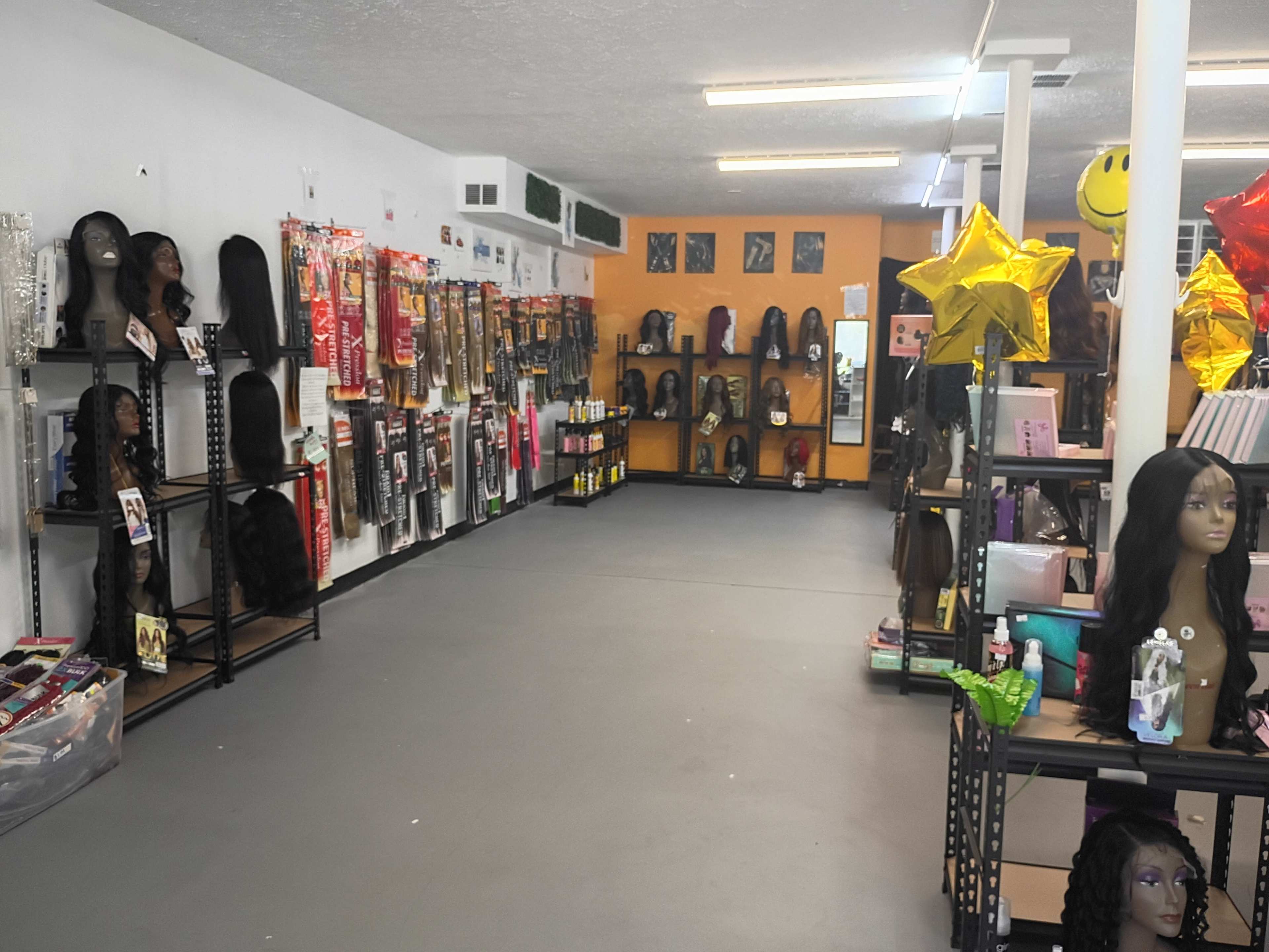 The image shows the interior of a hair supply store with shelves displaying wigs, hair extensions, and beauty products.