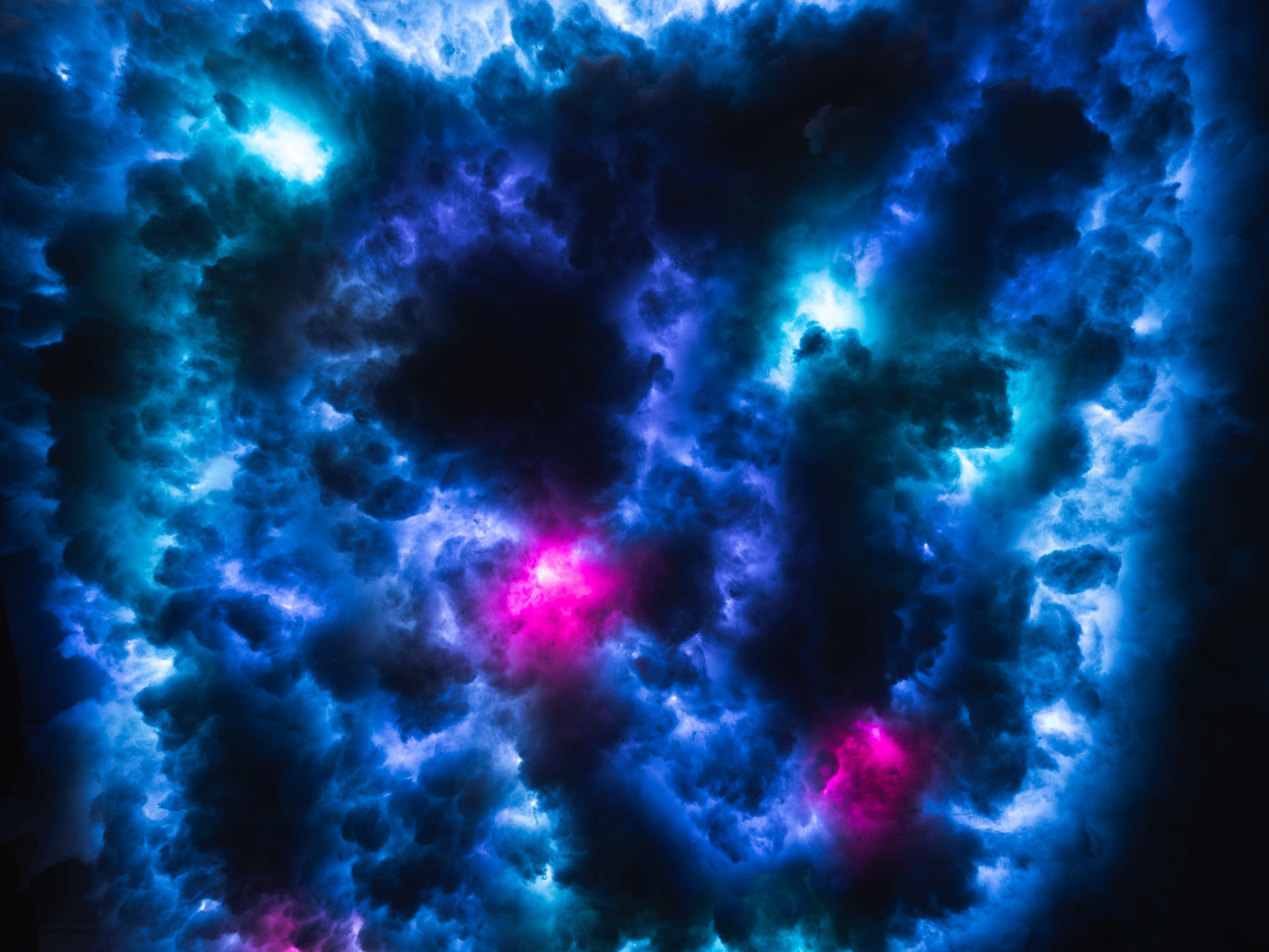 A dense array of clouds illuminated by blue and purple lights creates an ethereal atmosphere.