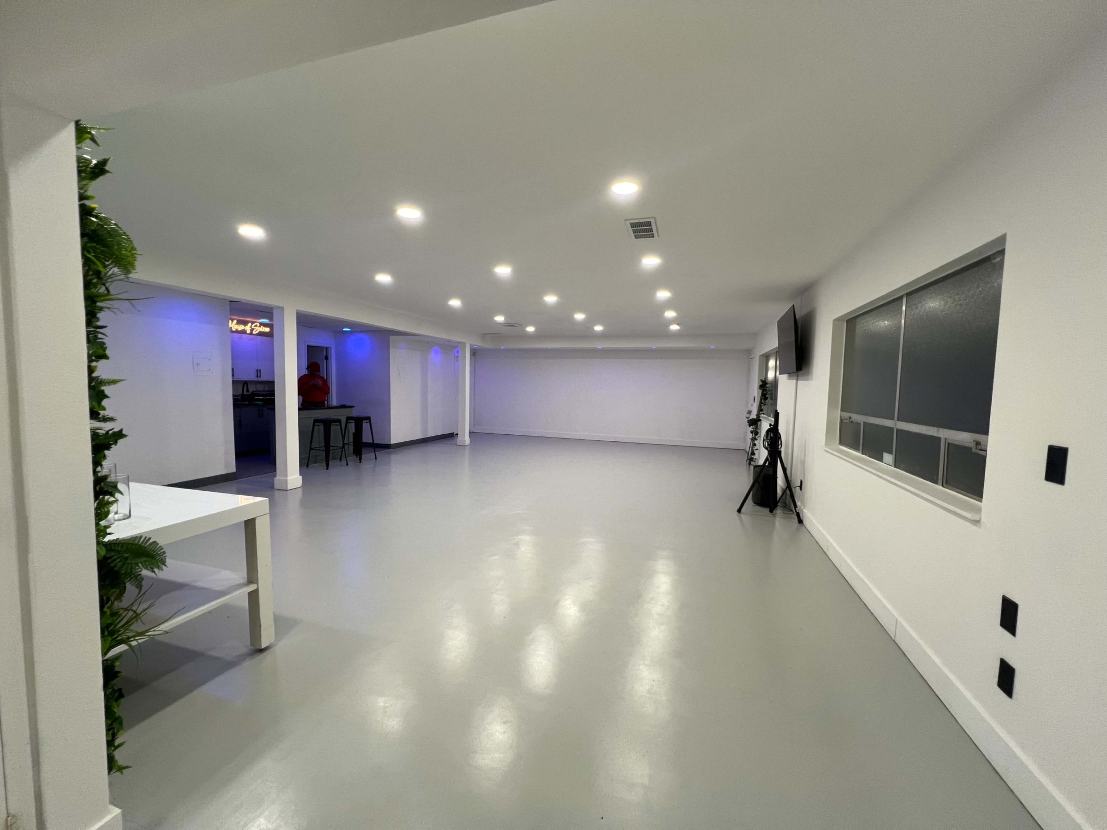 The spacious, well-lit interior features a polished gray floor with white walls and multiple ceiling lights.
