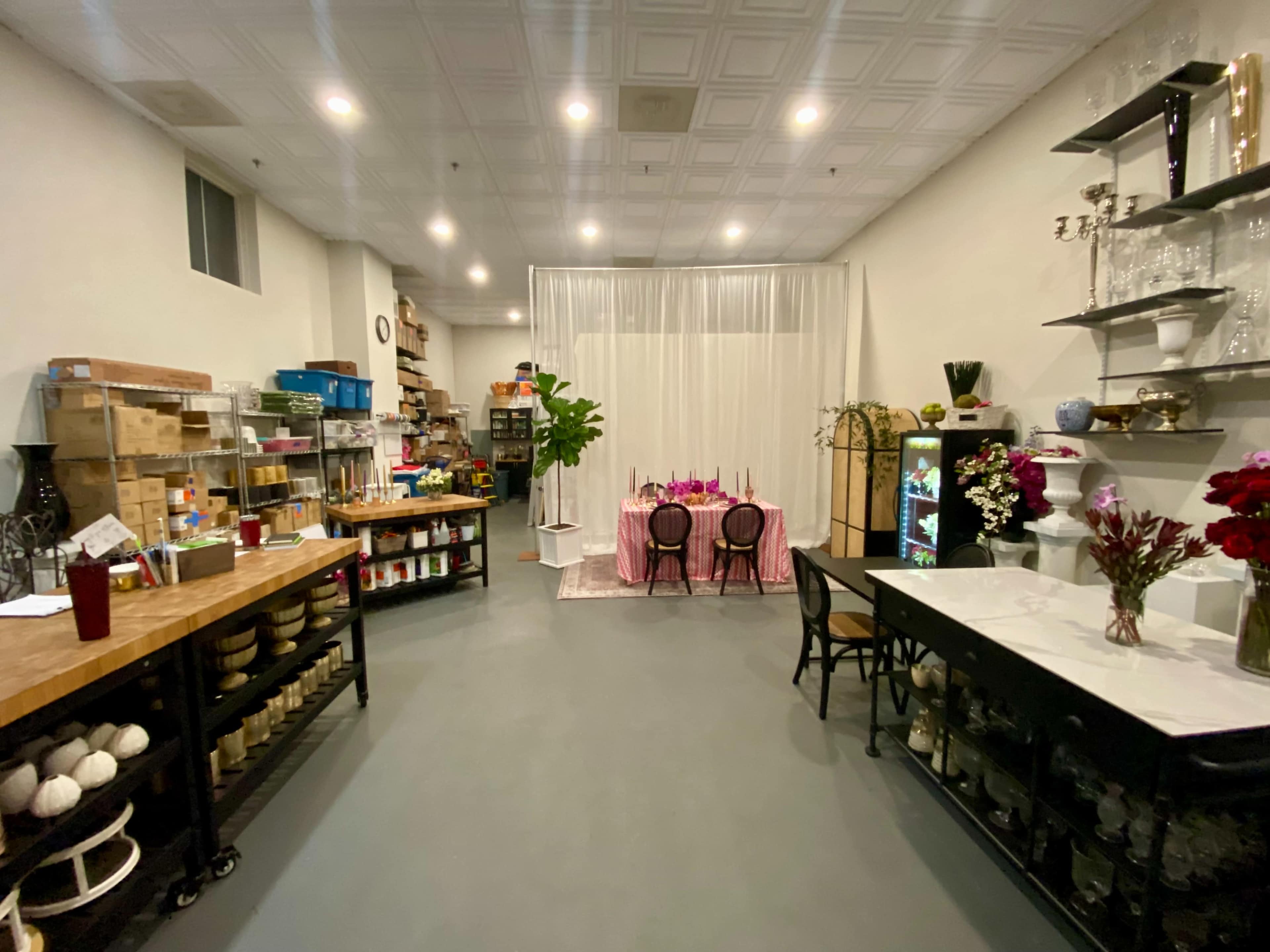 A spacious, well-organized interior with a dining table set for a meal, surrounded by shelves of supplies and storage areas.