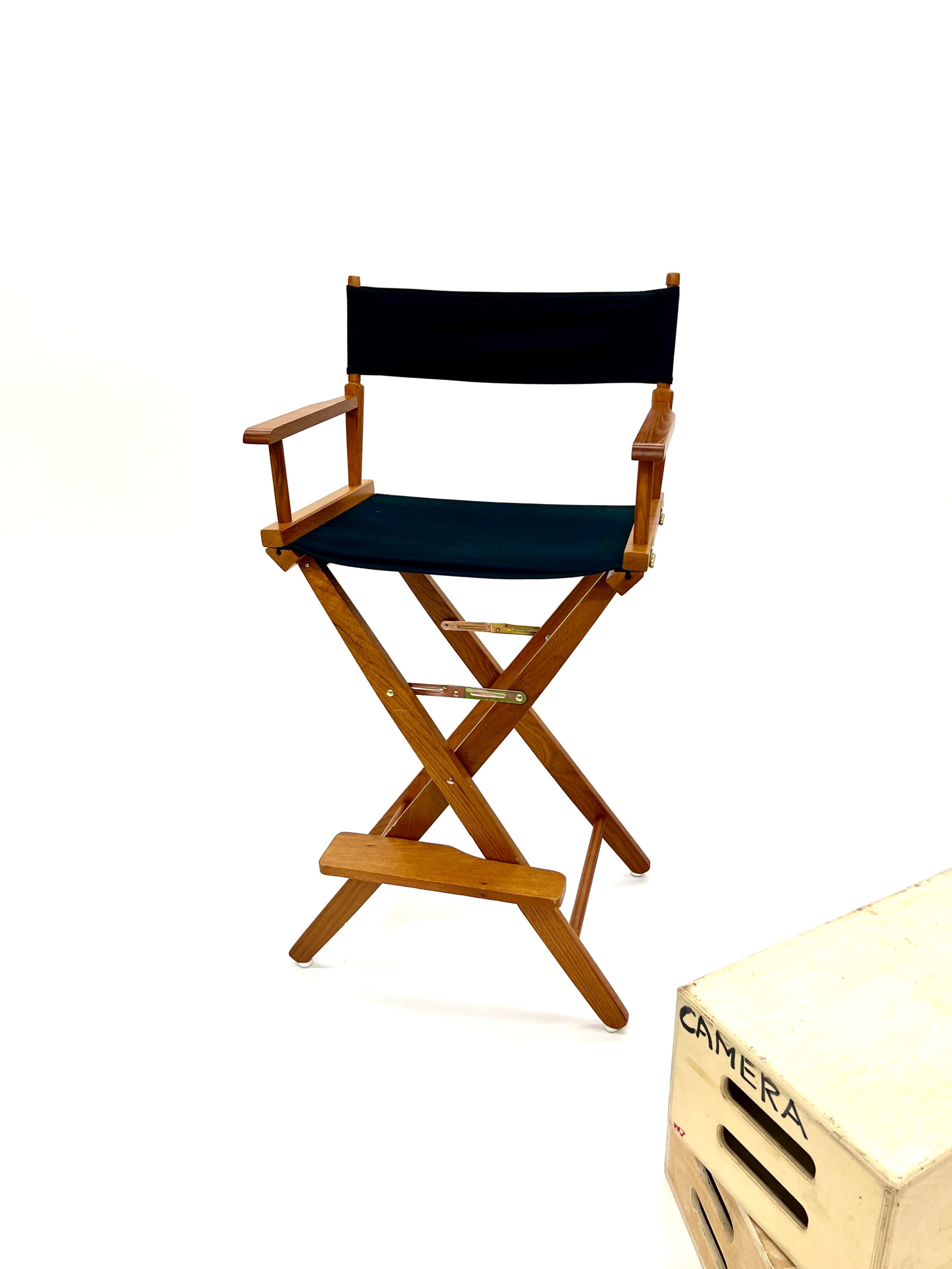 A black canvas director's chair is positioned next to a wooden box labeled "CAMERA."