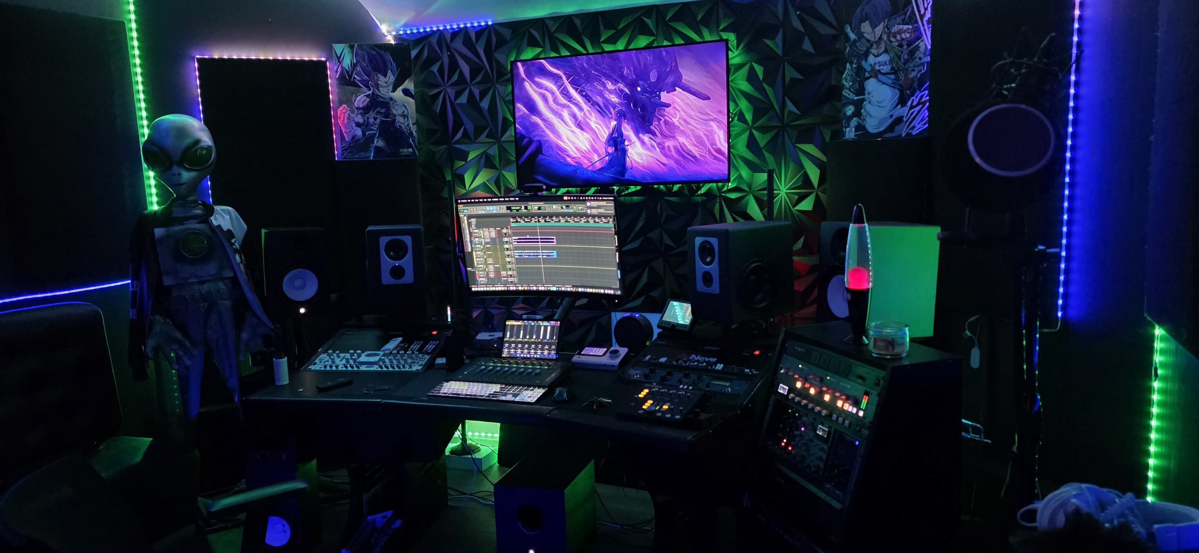 The image shows a modern music studio setup with a large screen displaying colorful visuals, multiple audio equipment pieces, and ambient lighting.
