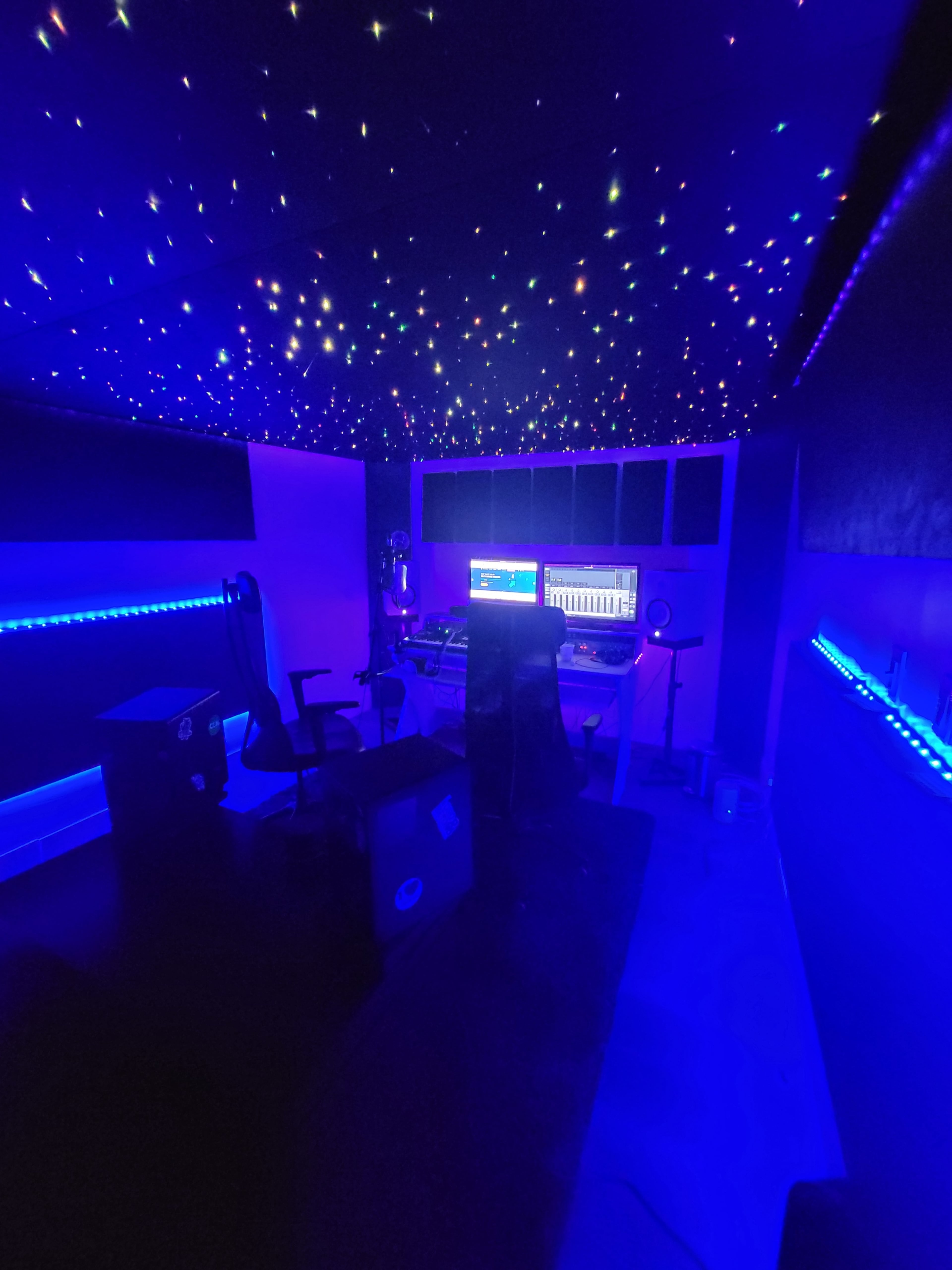 The image depicts a music production studio with a starry ceiling and blue LED lighting.