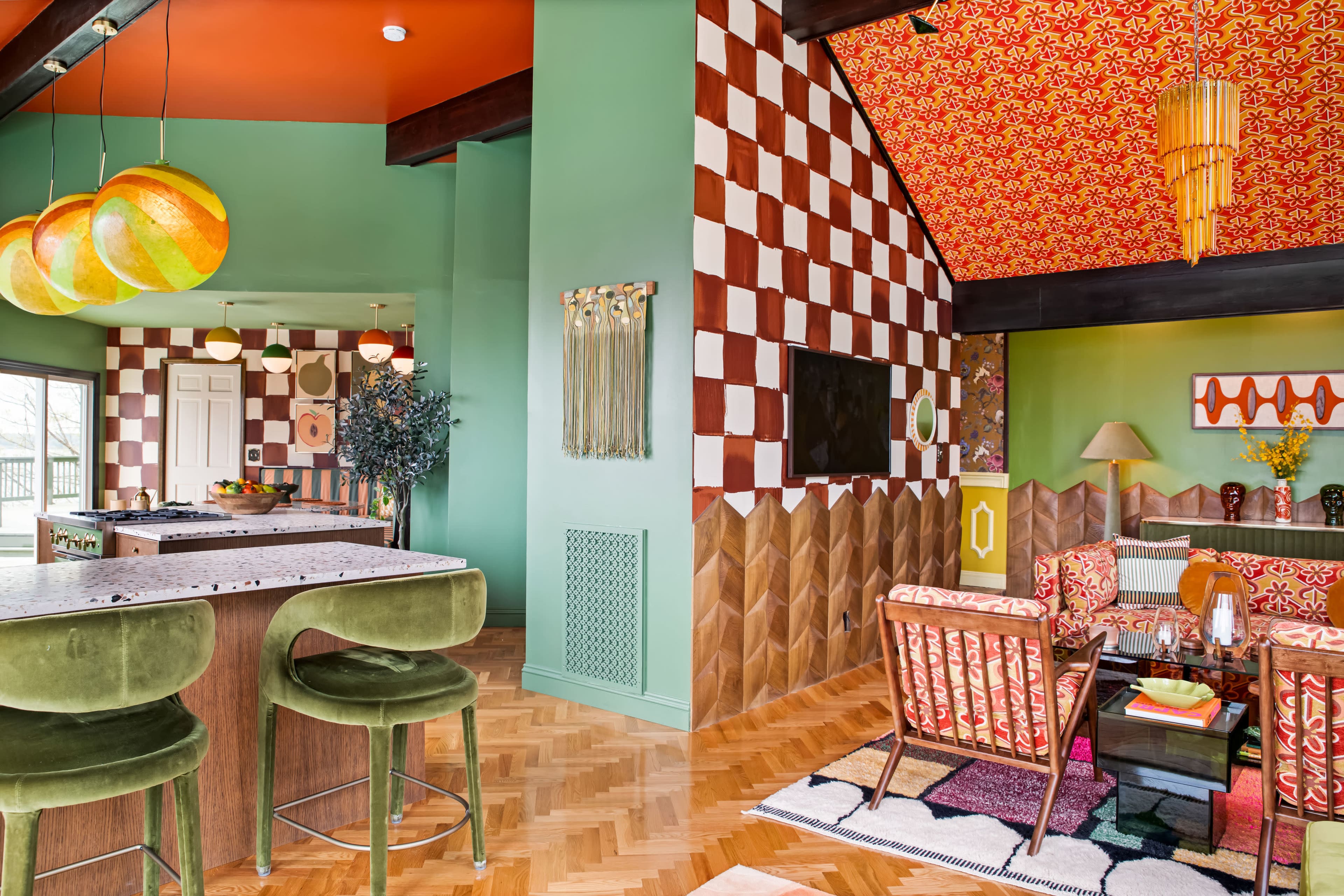 The image features a brightly decorated living space with green walls, a checkered patterned ceiling, and a combination of wood and colorful furniture.