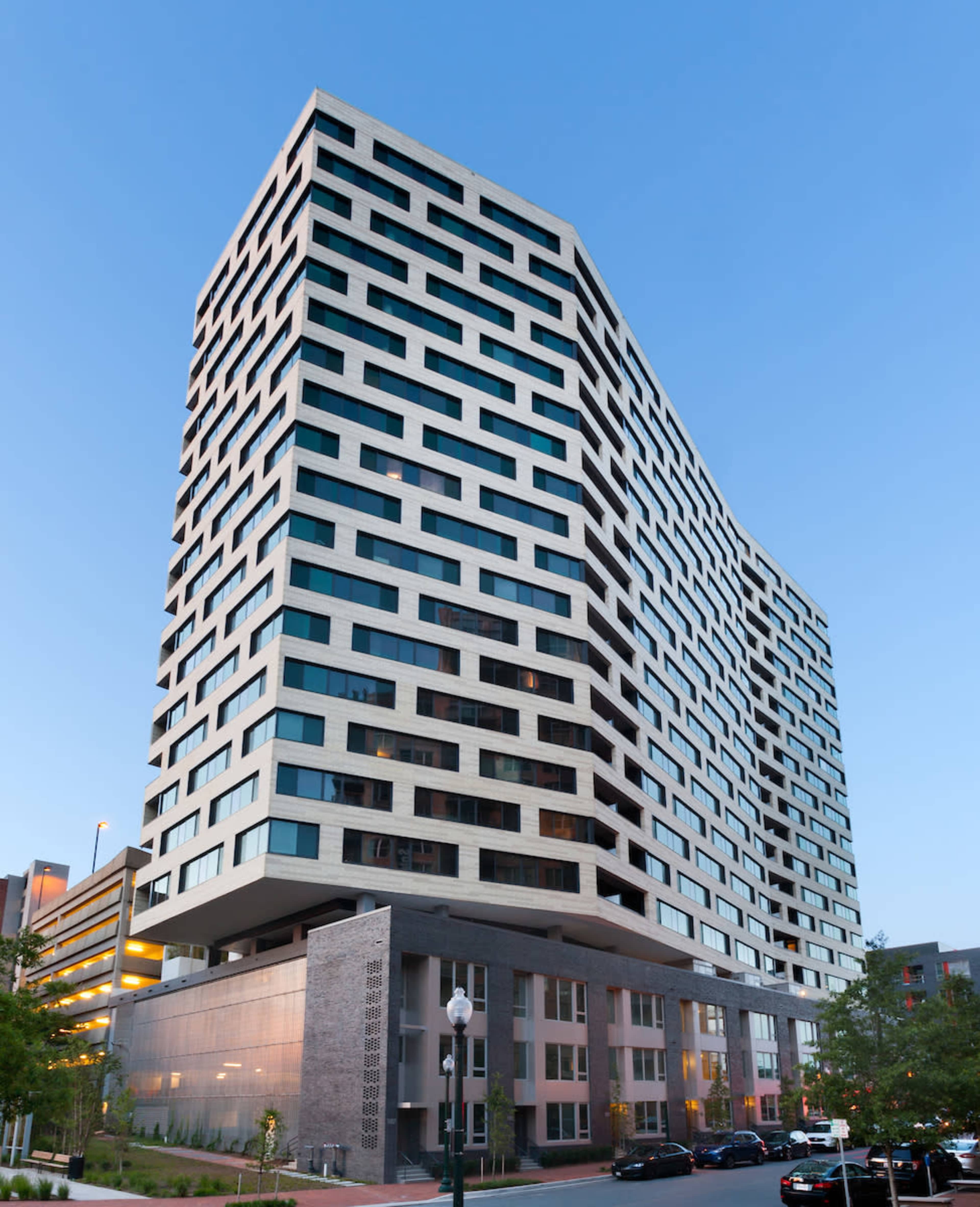 A modern, multi-story building features a unique geometric facade and large windows.