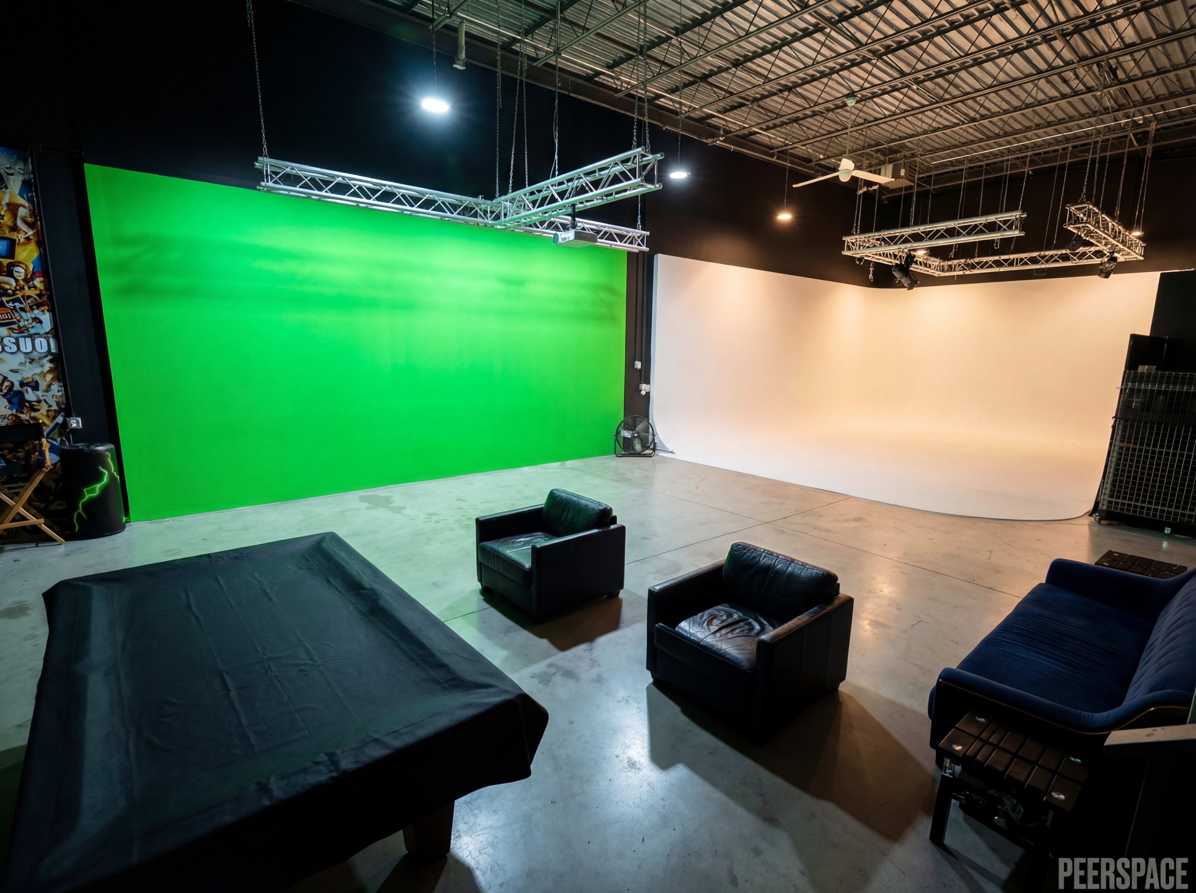 The image shows a rental studio space featuring a green screen on one wall, a white backdrop on another, and black leather couches in the seating area.