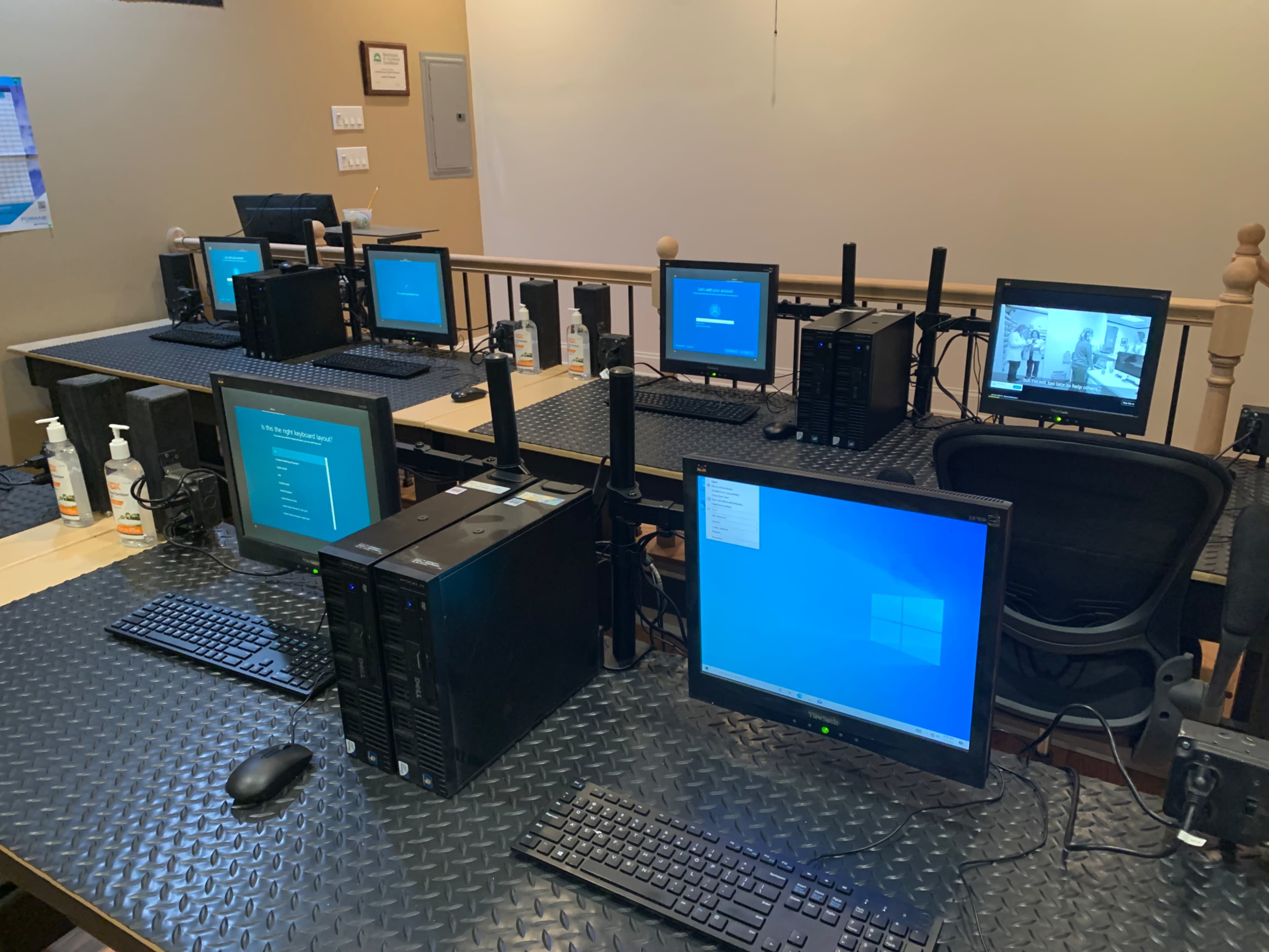 A row of desktop computers with monitors and keyboards set up on tables, featuring antennas for wireless connections.