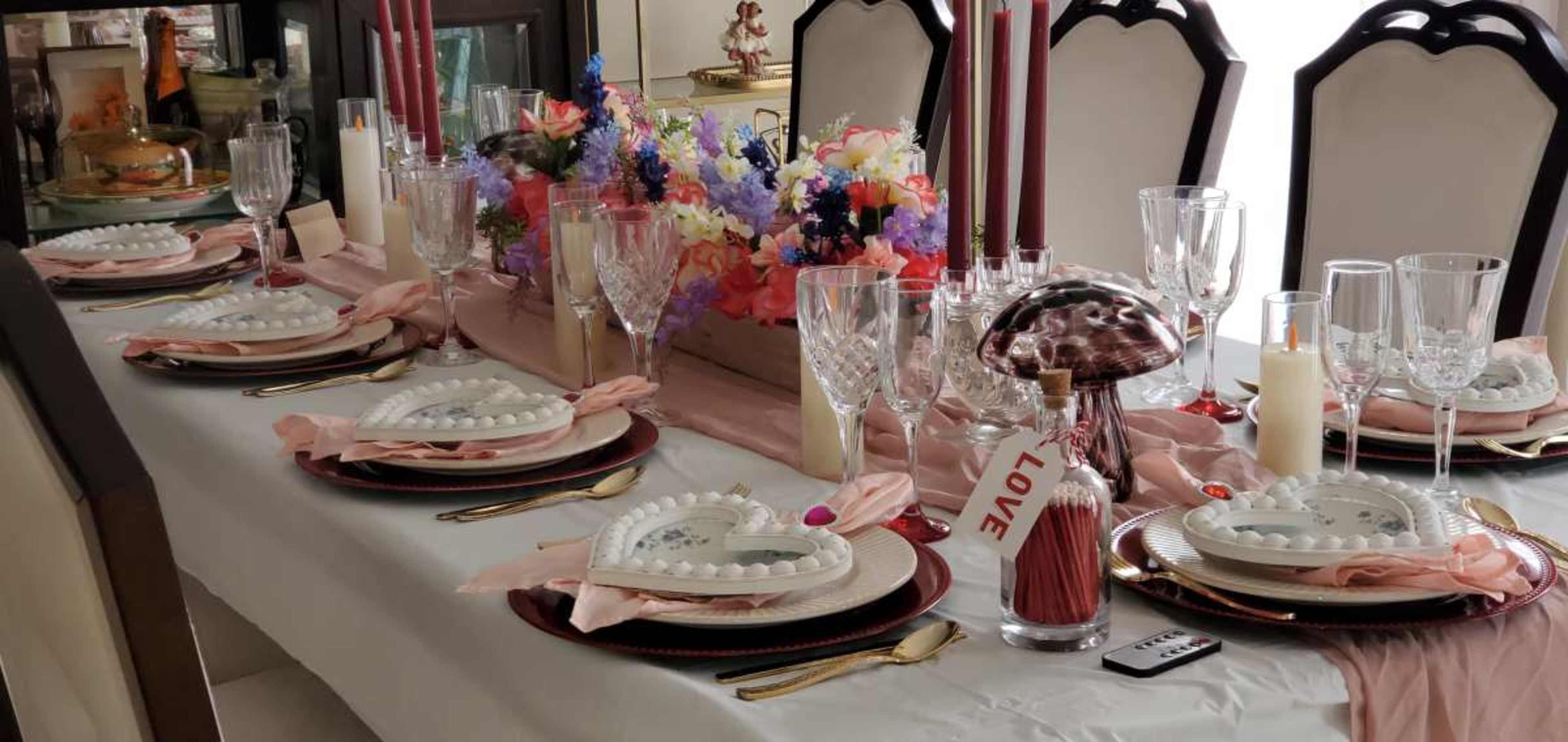 Love Fest/ Themed dinners/ private meetings.A romantic and intimate dinner party setting, perfect for Valentine's Day or a special occasion, featuring a beautifully decorated table with heart-shaped plates, candles, and flowers. Image in LaSalle, Buffalo, NY