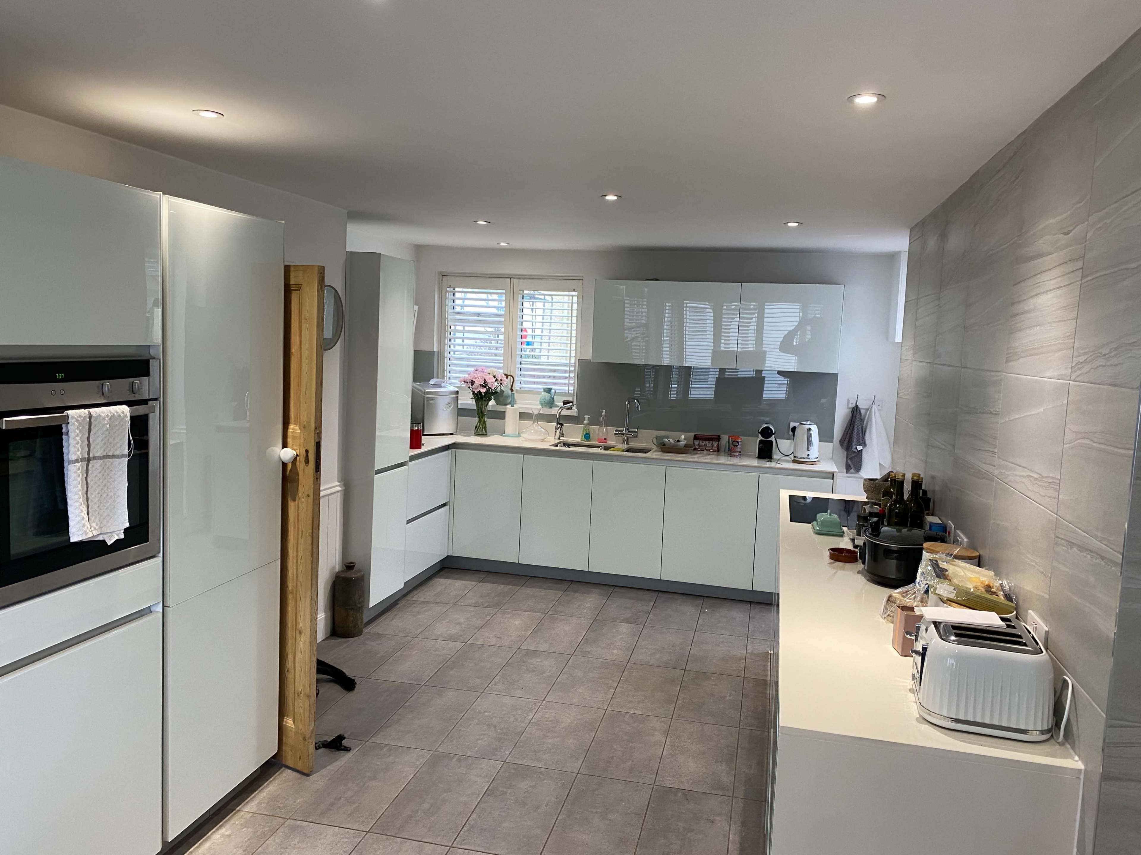 A modern kitchen featuring sleek cabinetry, stainless steel appliances, and a tiled floor.