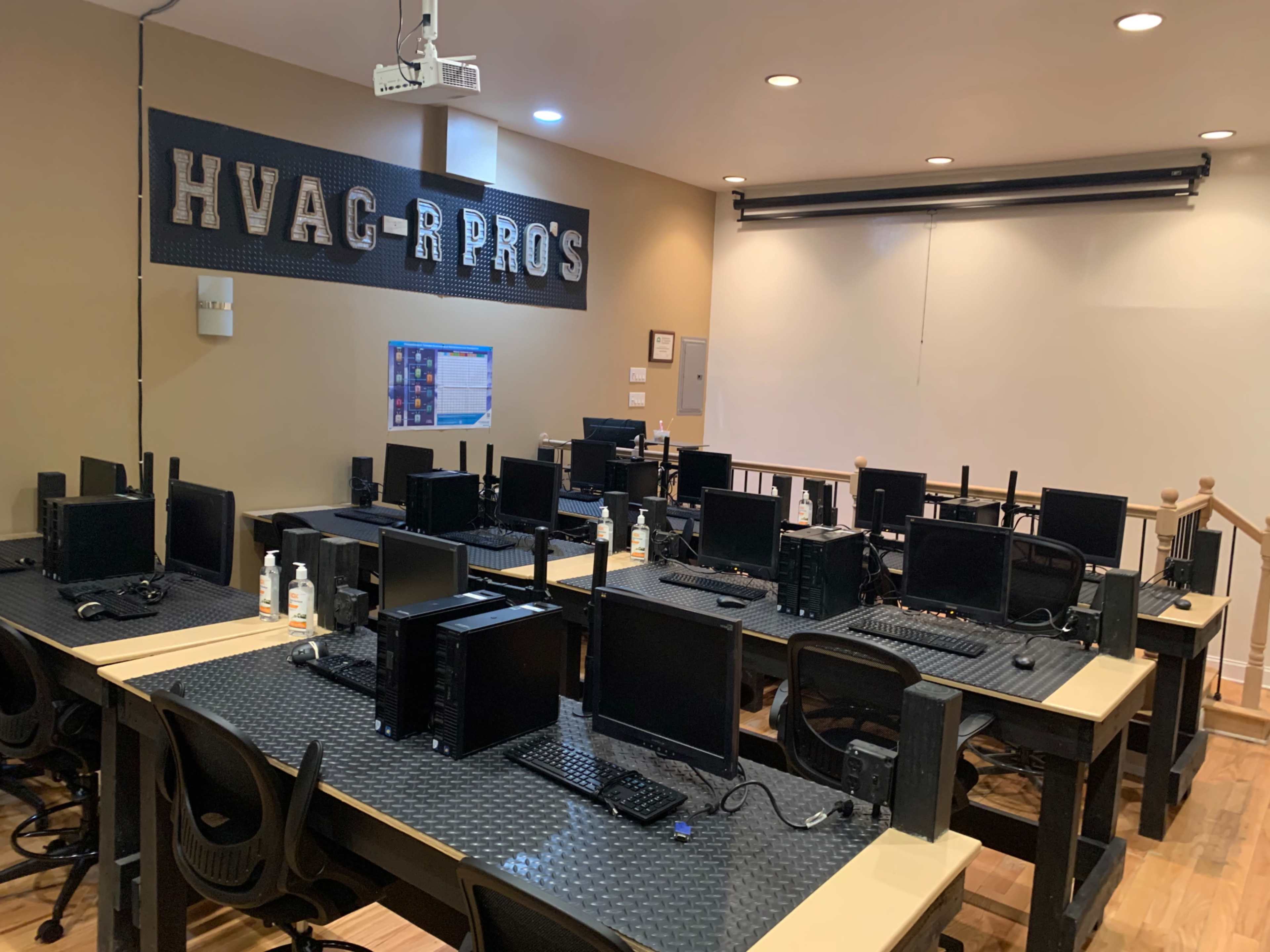 A classroom for HVAC-R training equipped with multiple computer stations and a projector.