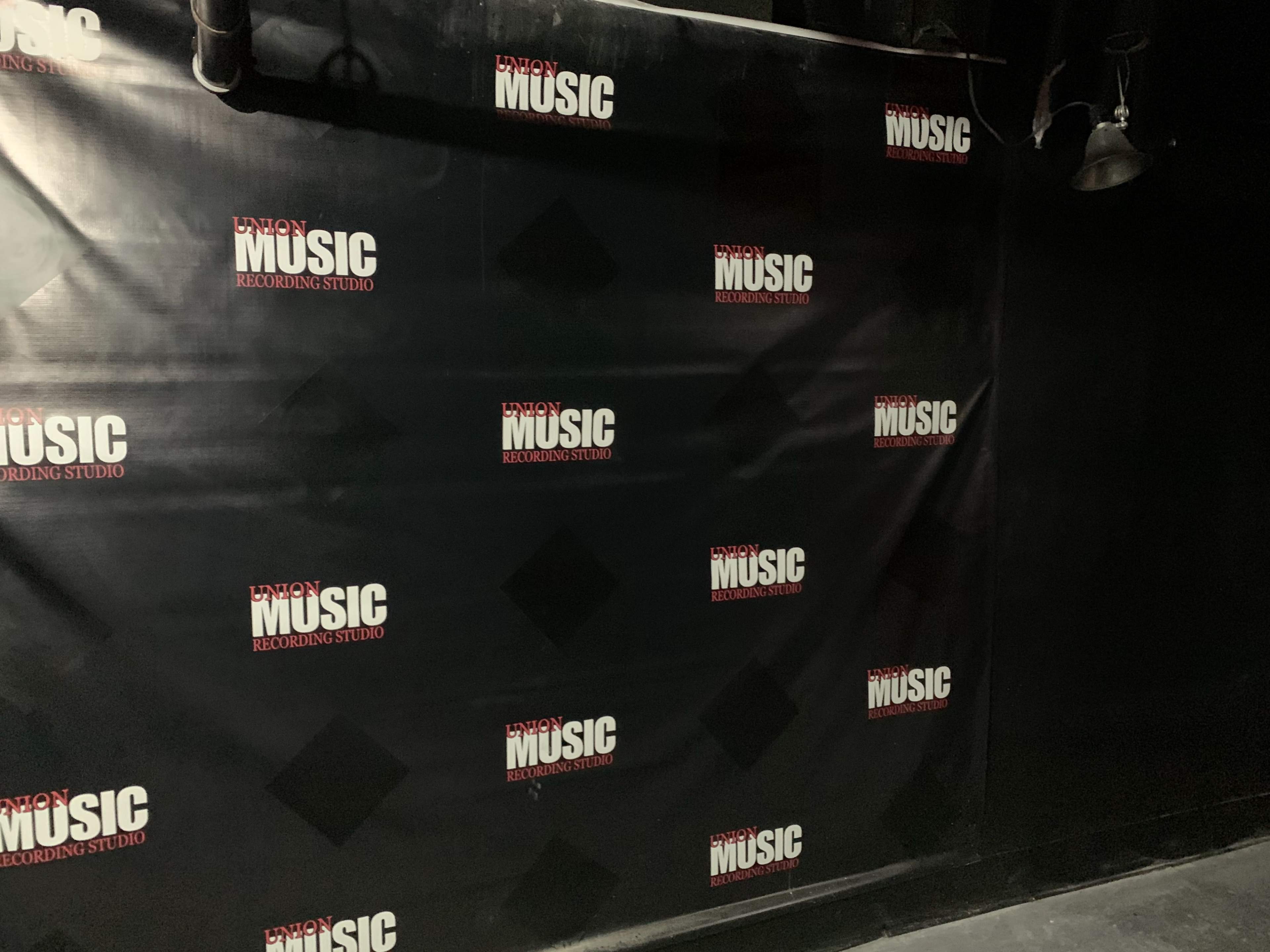A black wall covered with logos from Union Music Recording Studio.