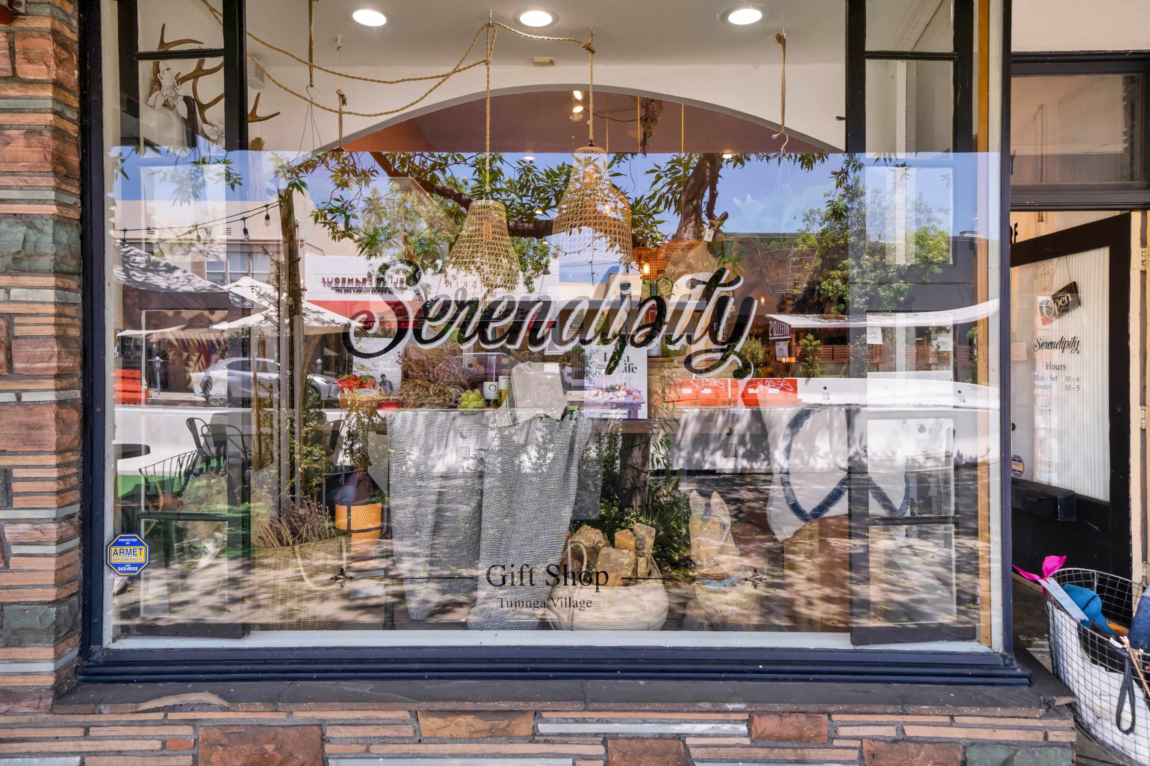 The image shows a storefront with the word "Serendipity" prominently displayed, featuring a well-decorated gift shop visible through the window.