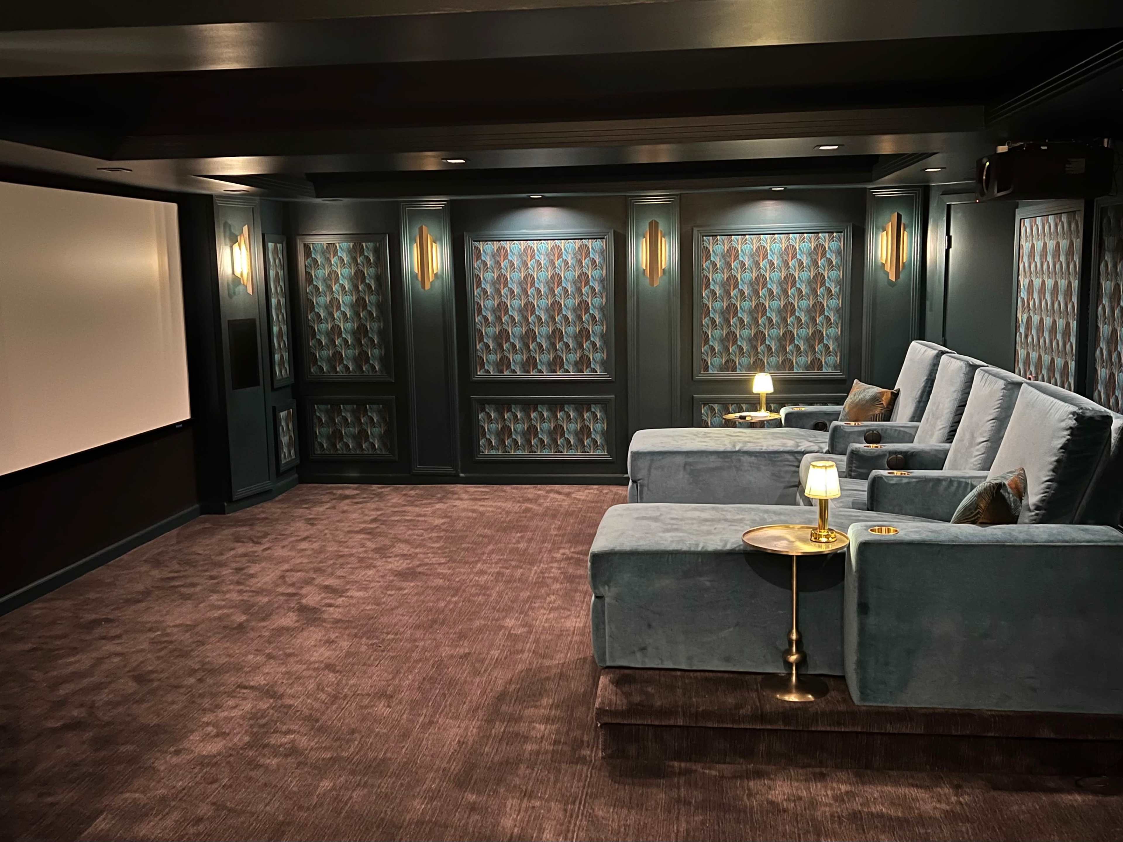 A home theater with plush seating, a large screen, and decorative wall panels.