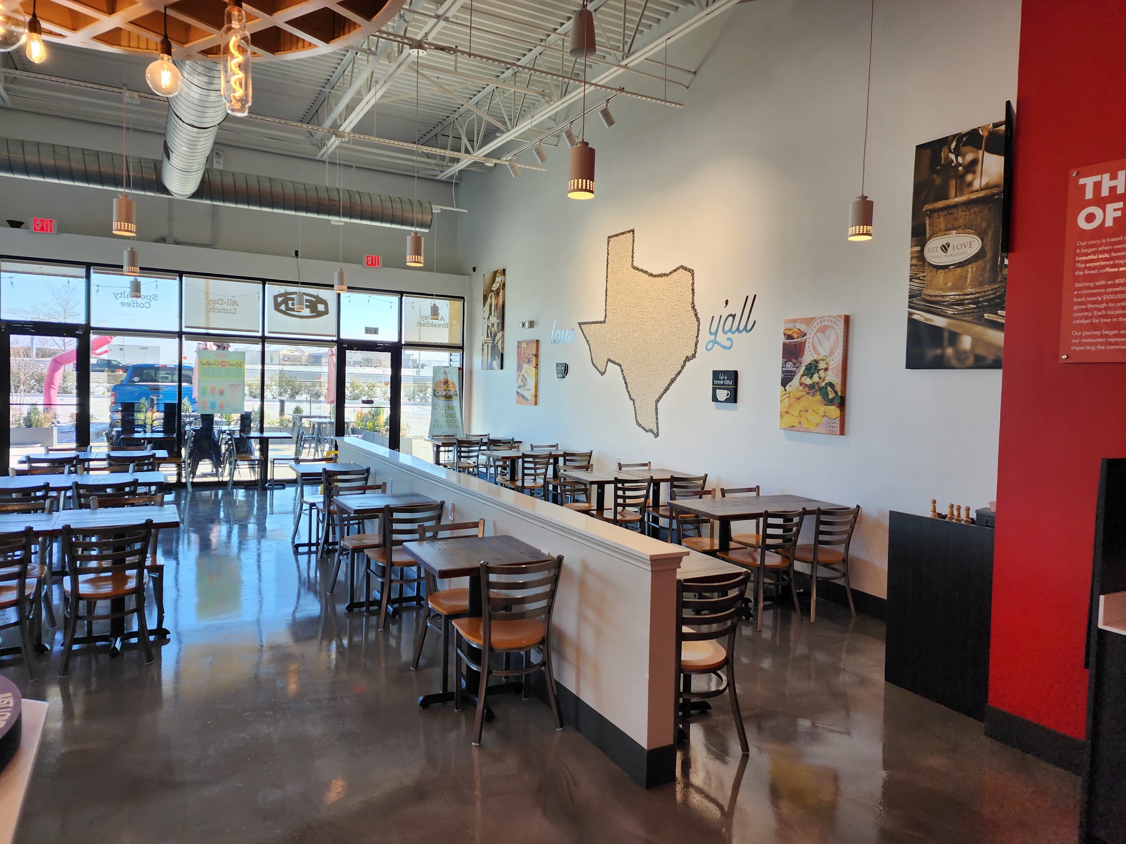 An interior view of a restaurant with a Texas map on the wall, featuring tables and chairs arranged for dining.