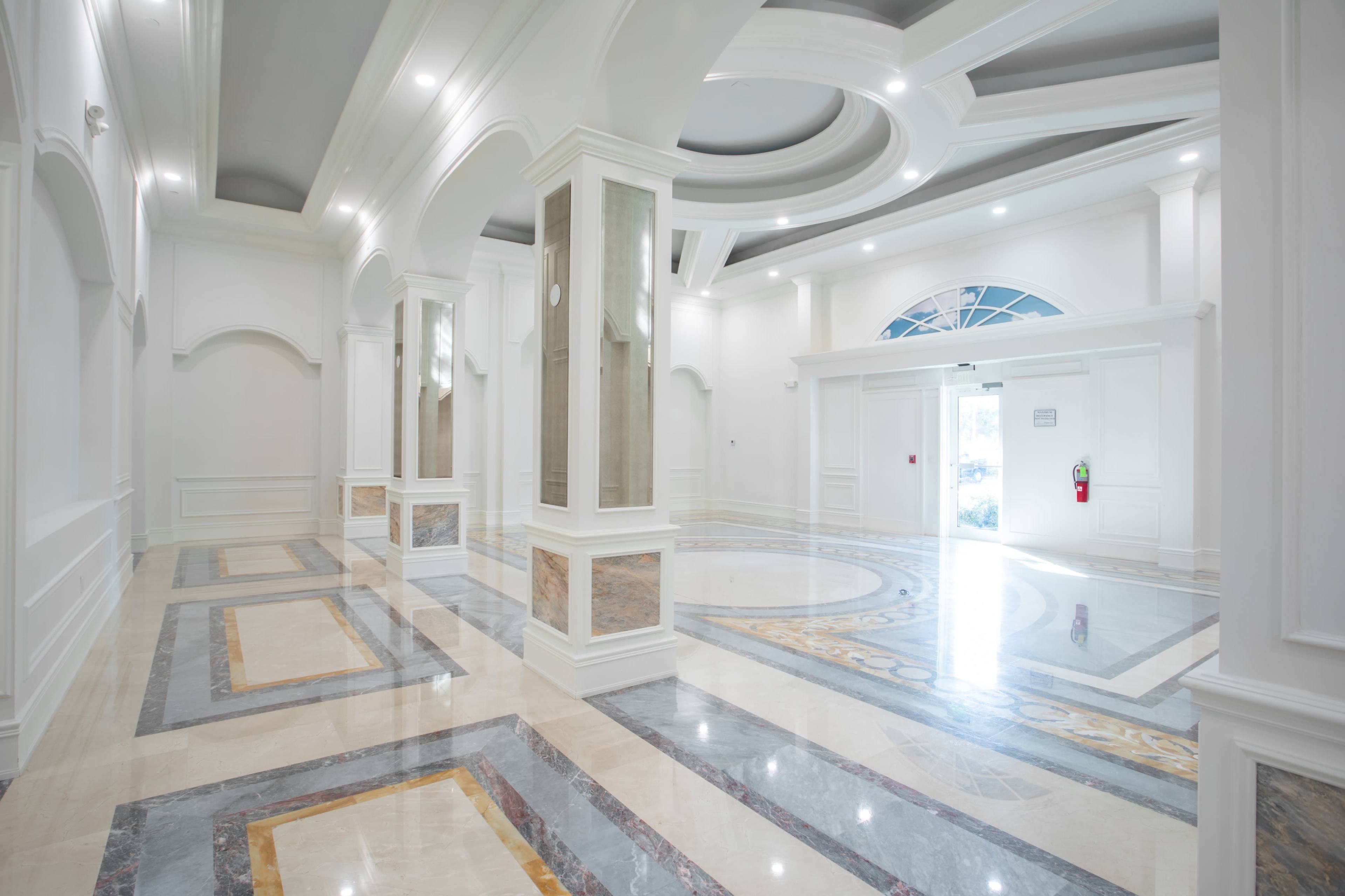 A spacious, modern lobby with polished marble floors and elegant architectural details.