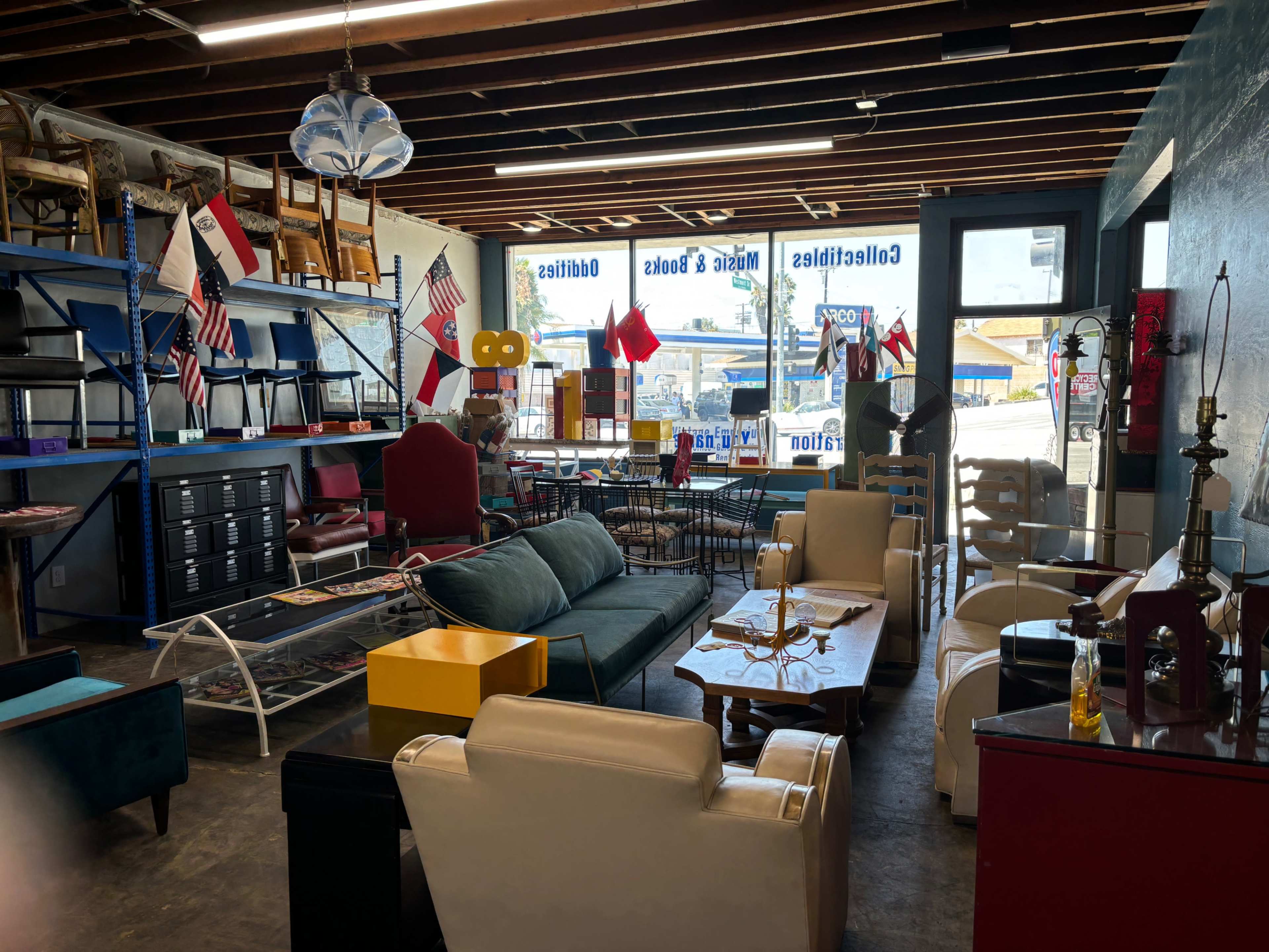 An interior of a furniture store with various seating options, shelves displaying items, and multiple flags hanging from the ceiling.