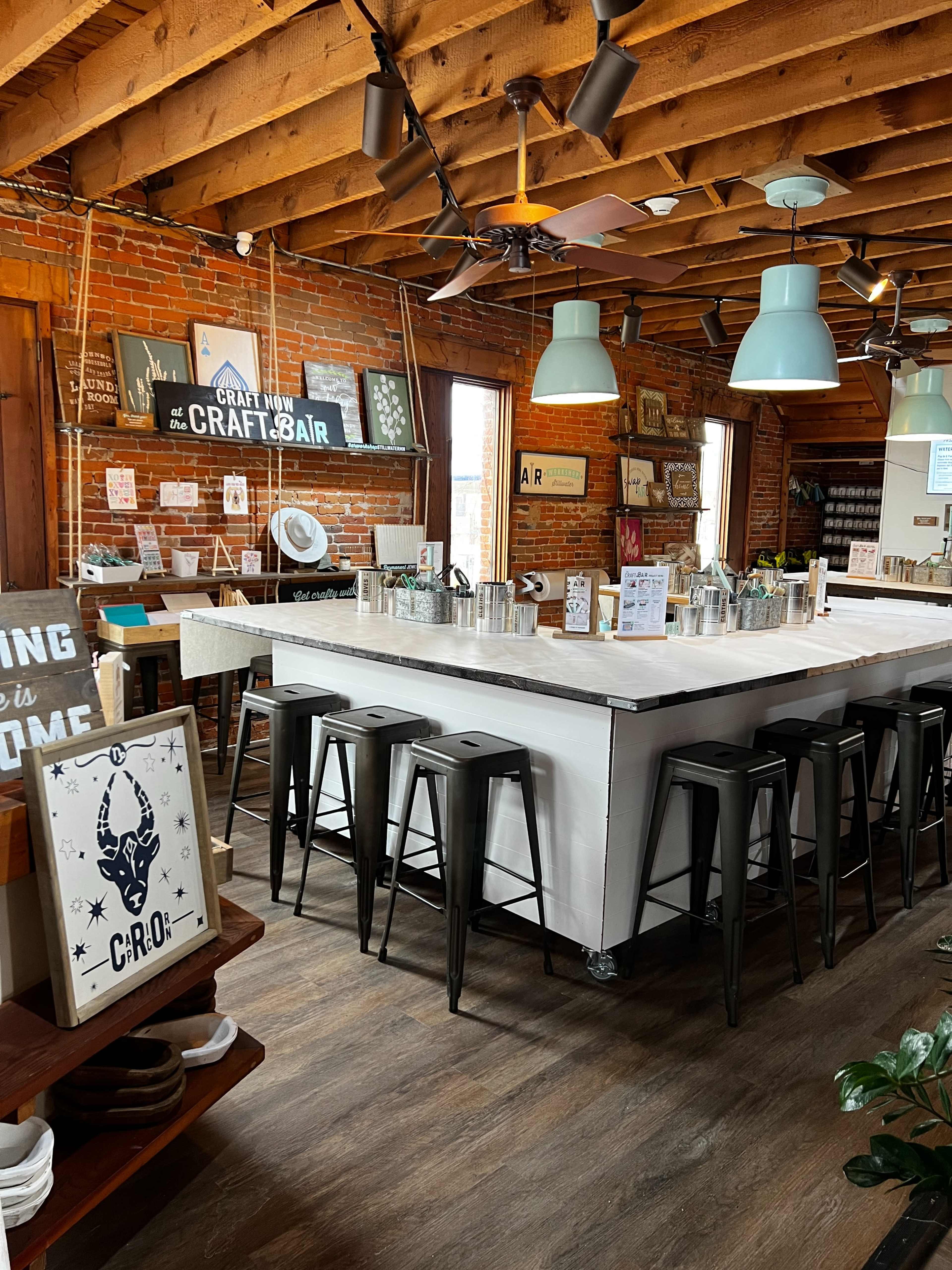 The scene shows a rustic-style bar area with industrial stools, wooden beams, and brick walls, adorned with various signs and decor.