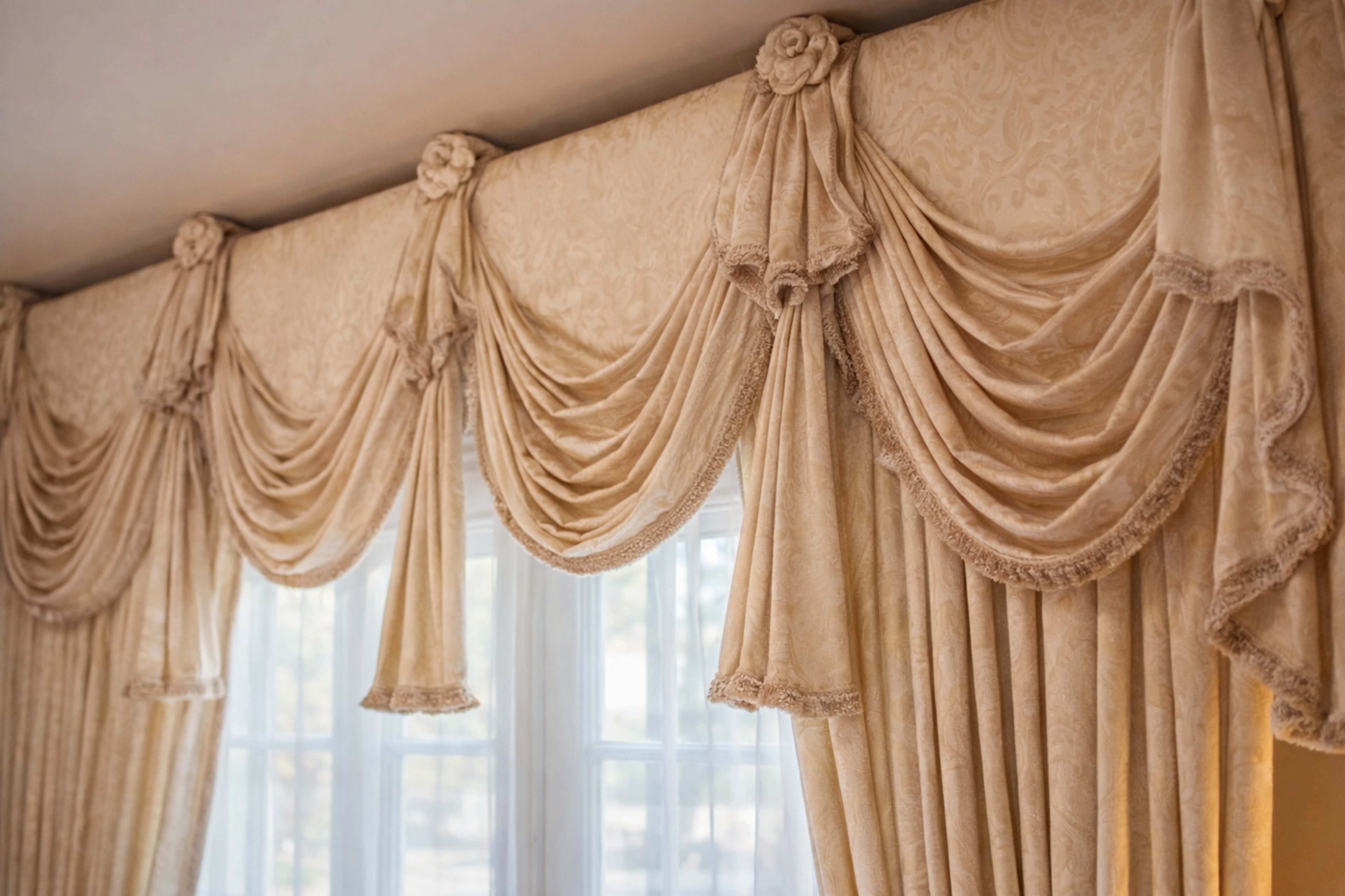 The image shows elaborate curtains and valances with pleated designs hung above windows.