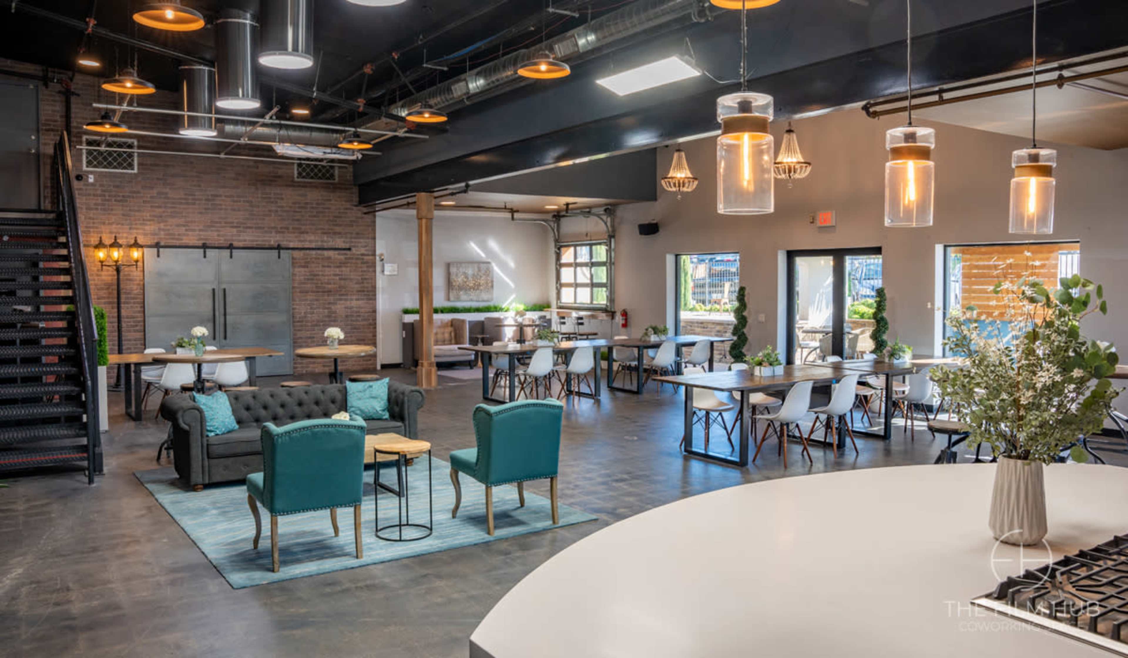 A modern, open-layout restaurant with seating areas, a bar space, and decorative lighting.