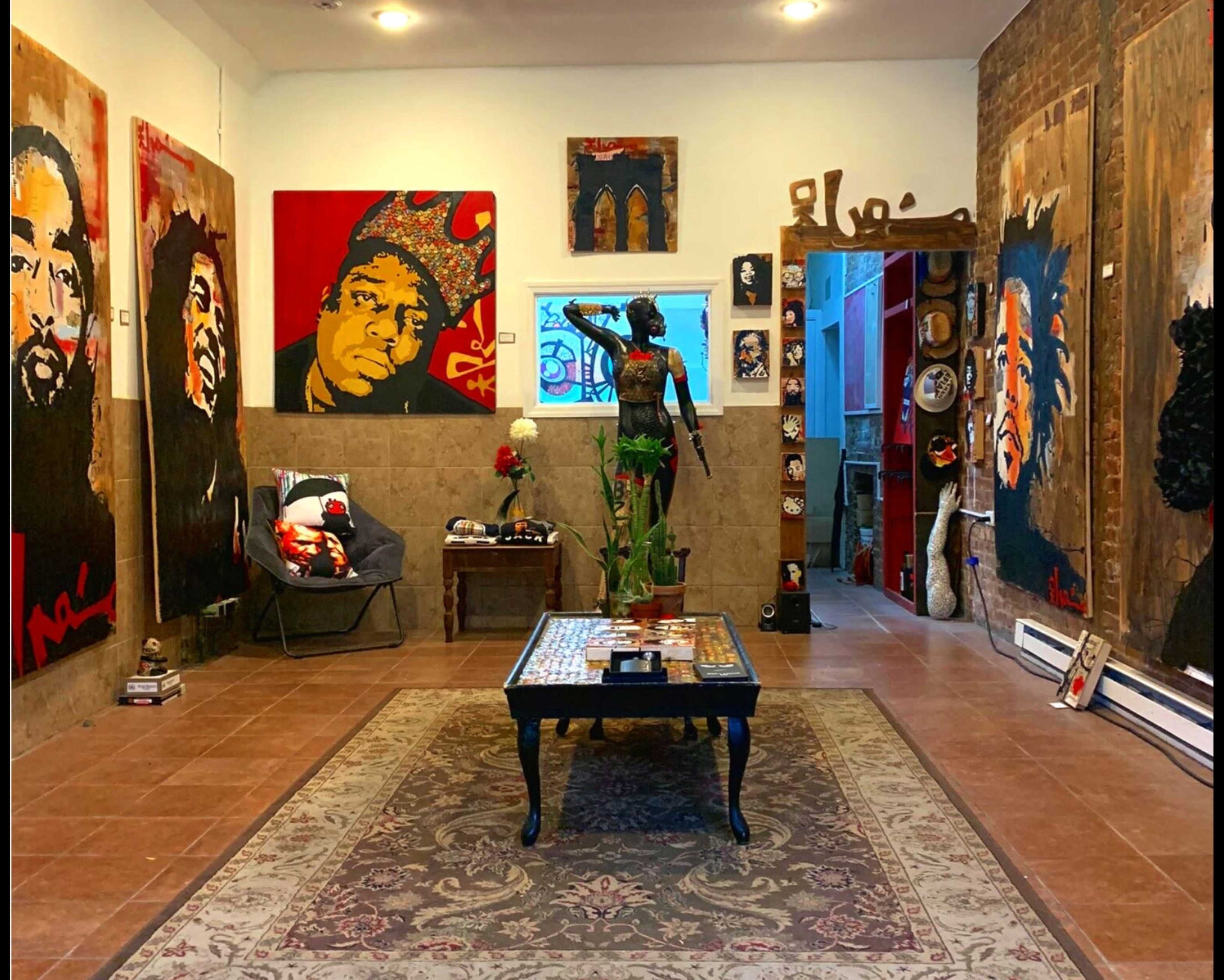 An art gallery interior featuring several large, colorful portraits on the walls, a decorative table in the center, and a statue in an alcove.