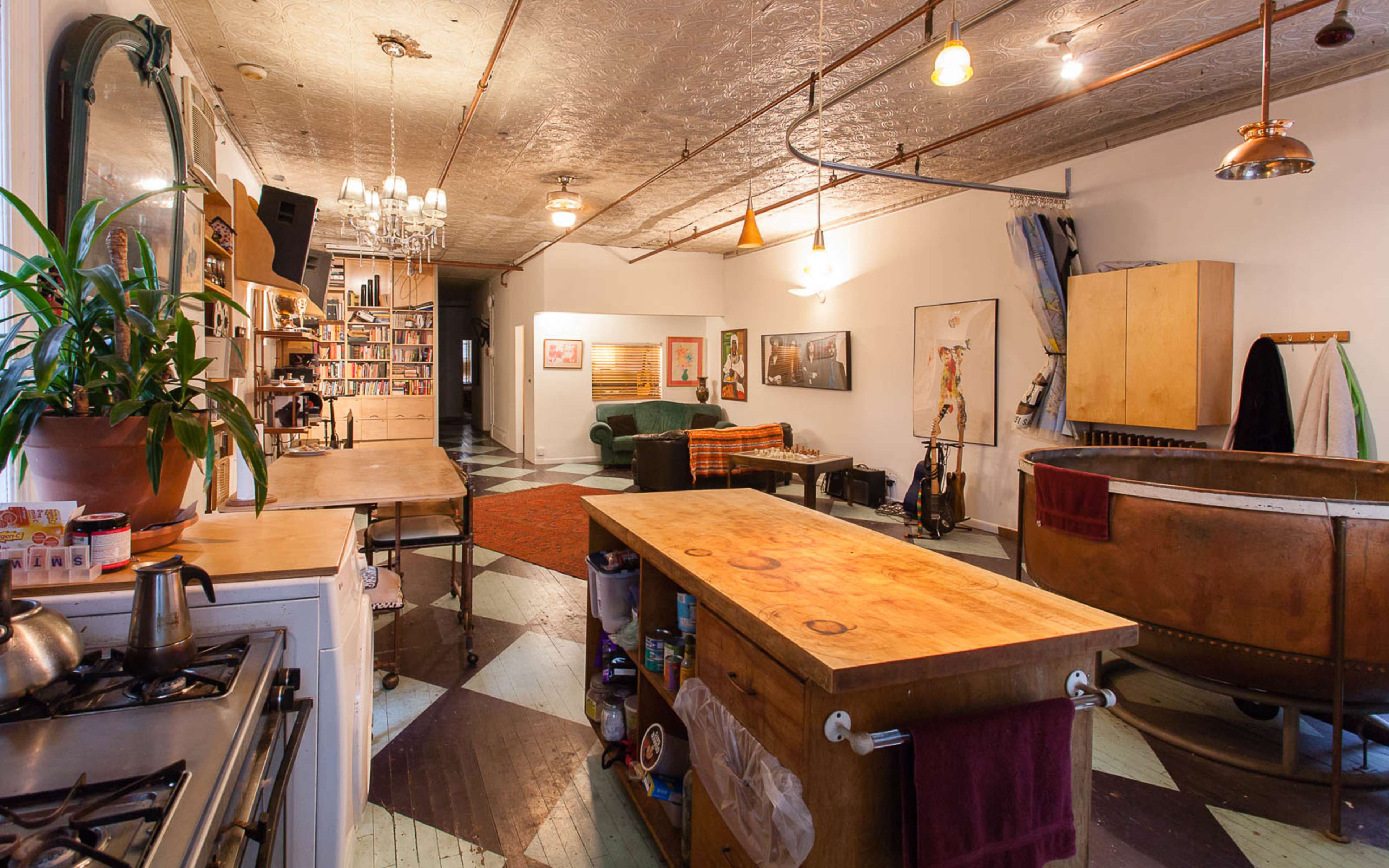 A spacious, open-concept kitchen and living area features wooden countertops, vintage decor, and a cozy seating arrangement.