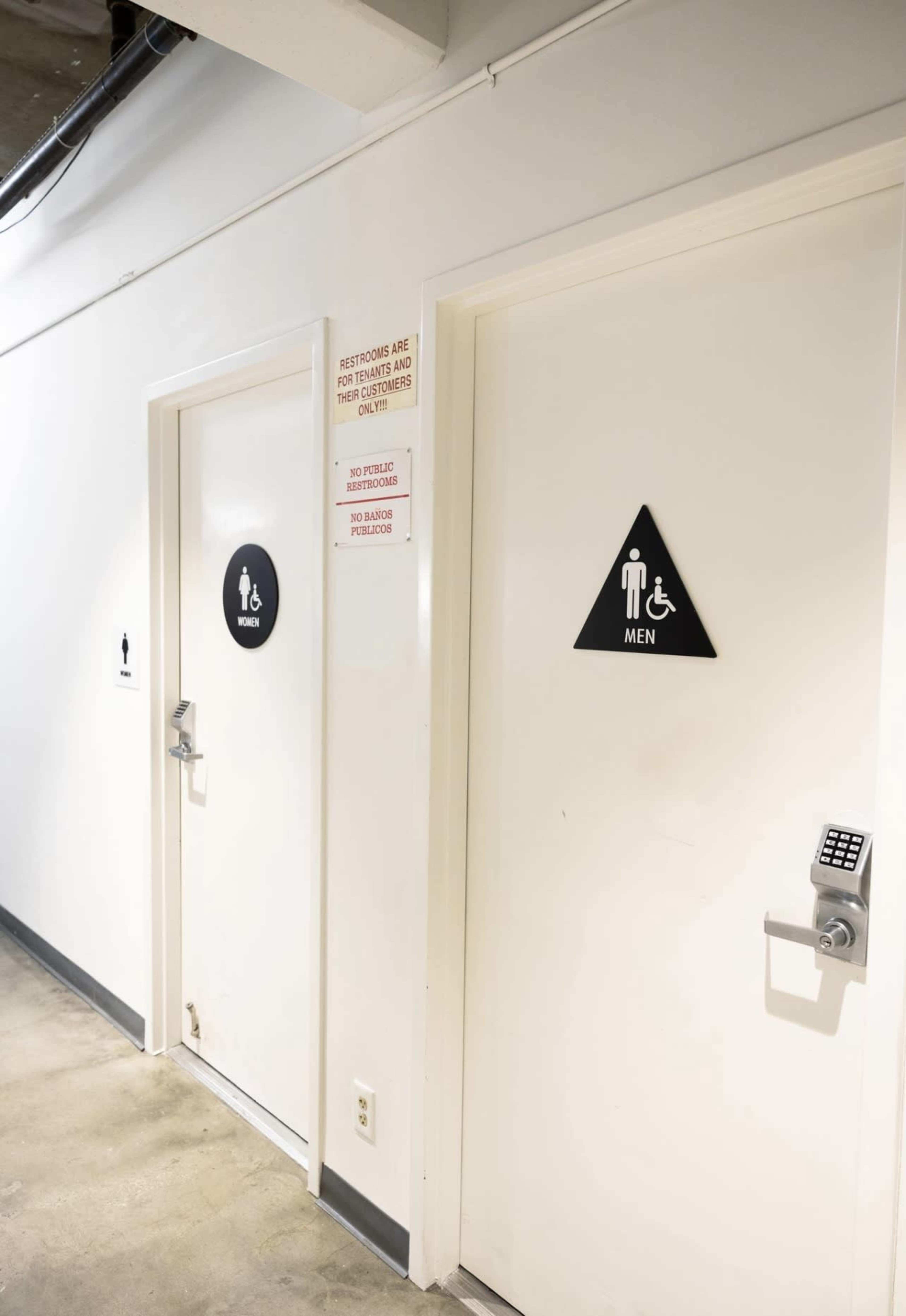 The image shows two restroom doors; one labeled "Men" with a figure symbol, and the other with a universal accessibility symbol.