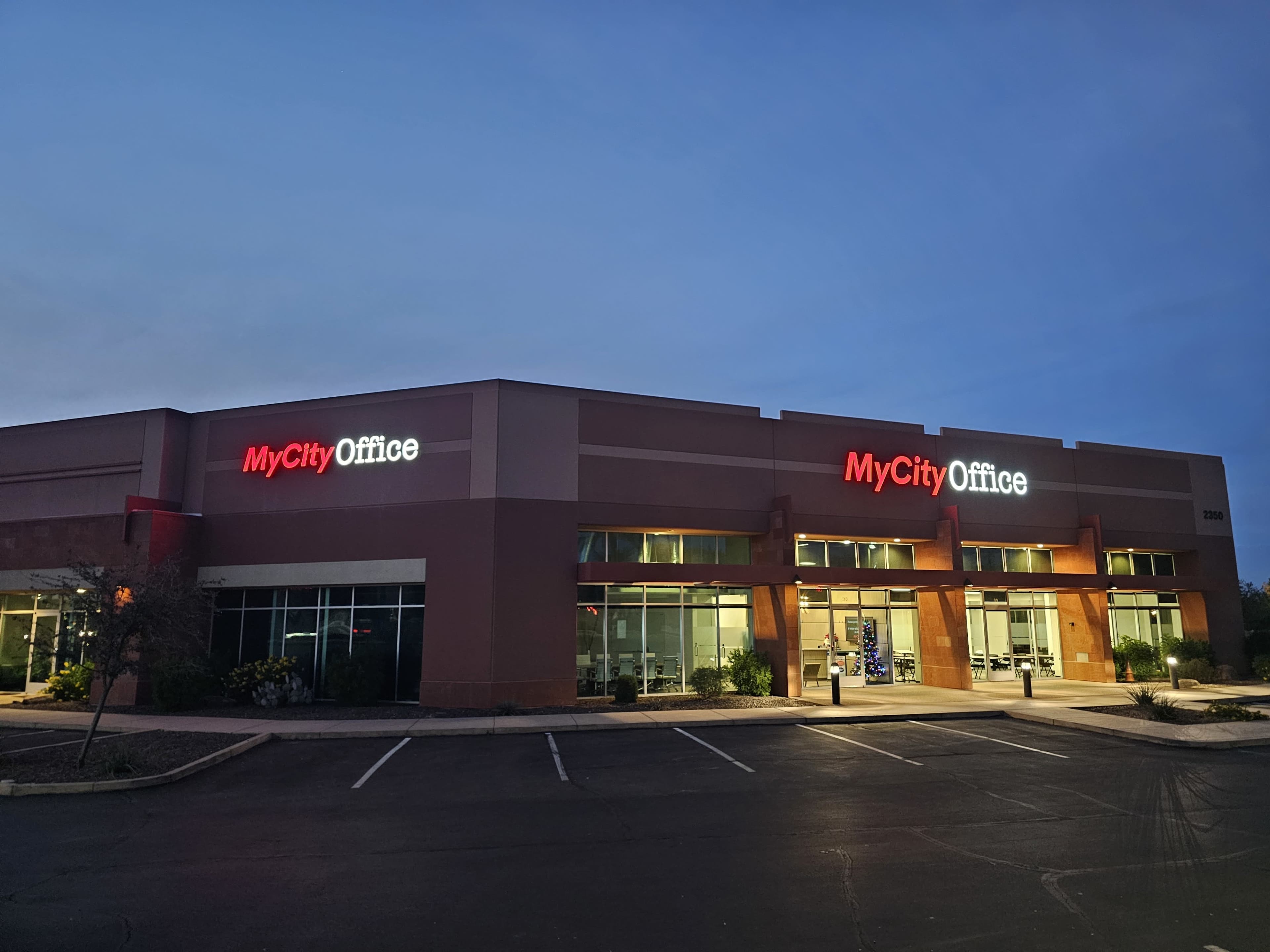 The image shows a commercial building with "MyCity Office" prominently displayed on the signage, set against a twilight sky.