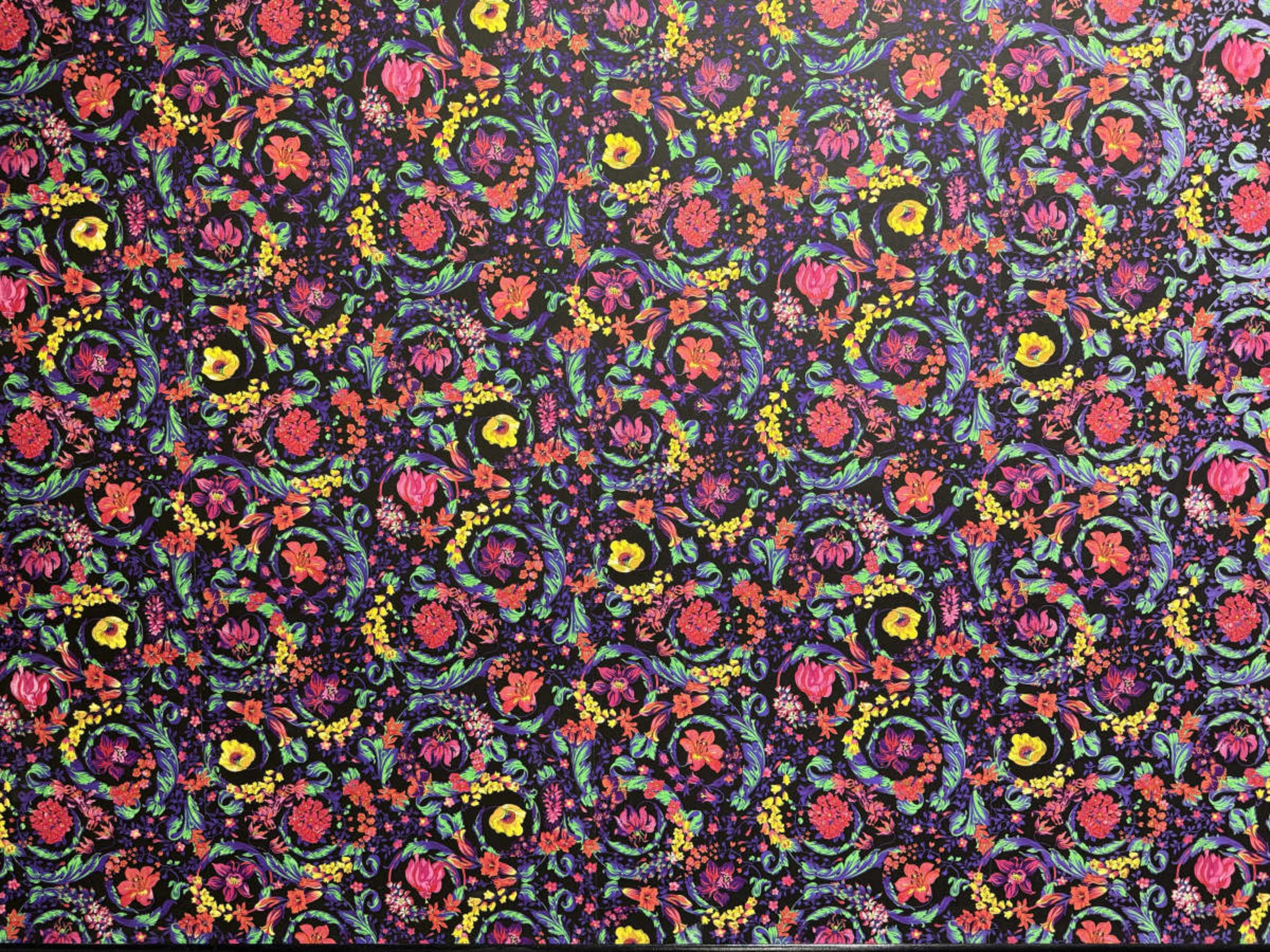 The image shows a vibrant floral pattern featuring various flowers in bright colors set against a dark background.