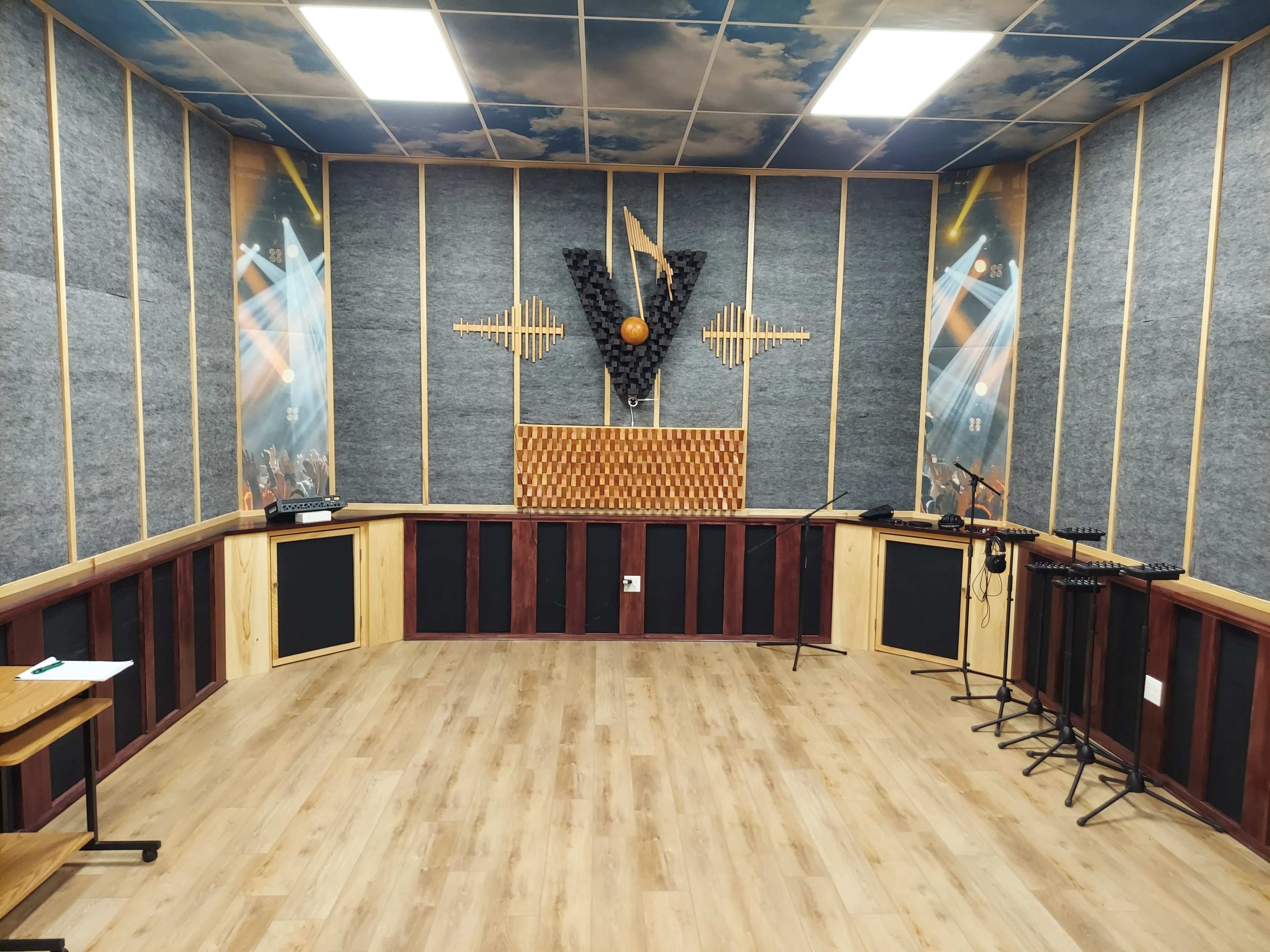 A sound studio with soundproofed walls, wooden panels, and various musical instruments arranged against one side.