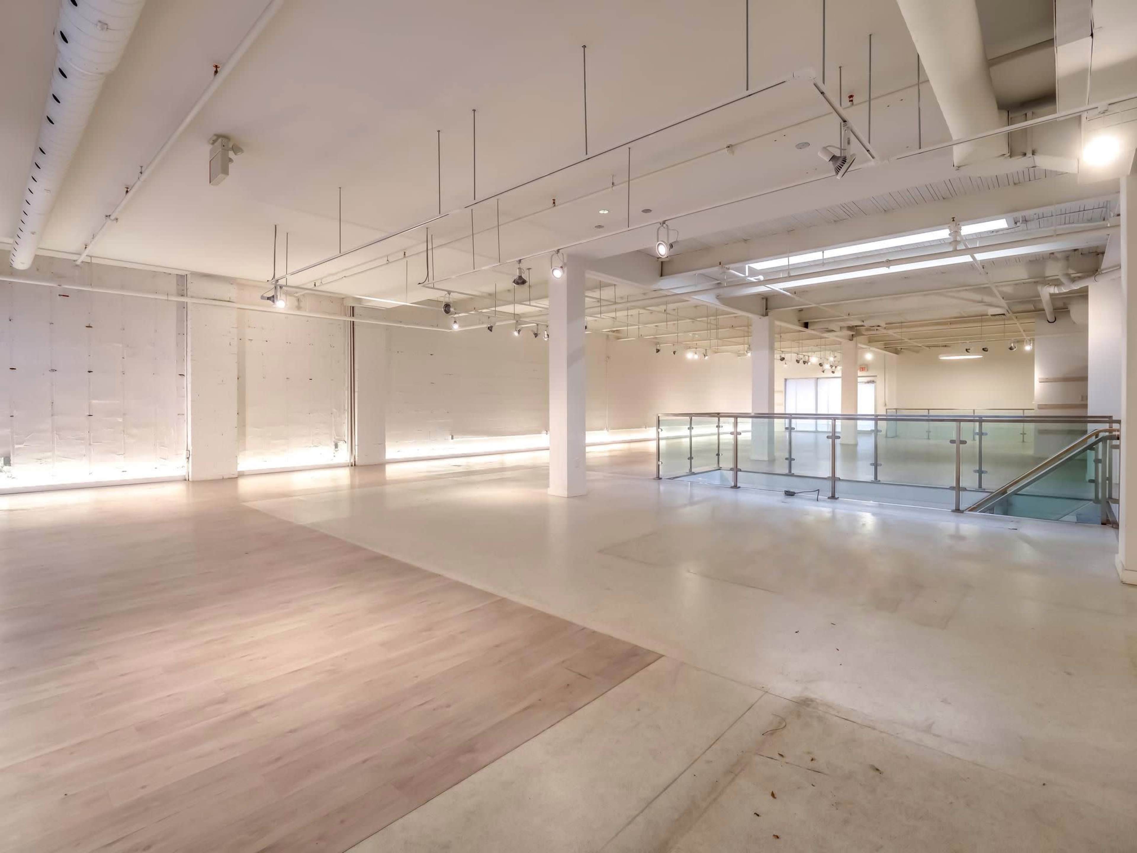 An empty, spacious interior area with polished floors and large windows providing natural light.