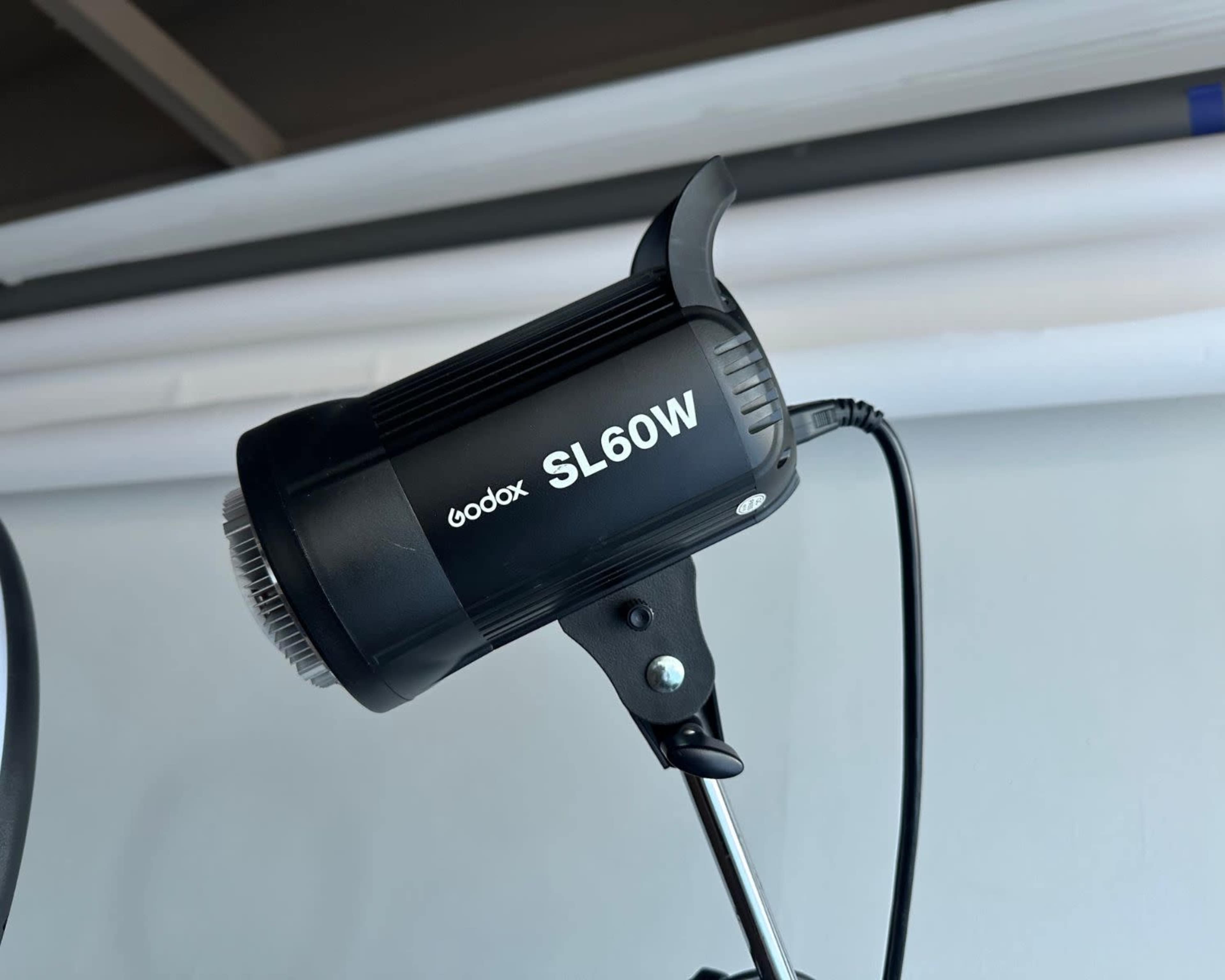 A Godox SL60W lighting unit mounted on a stand against a plain background.